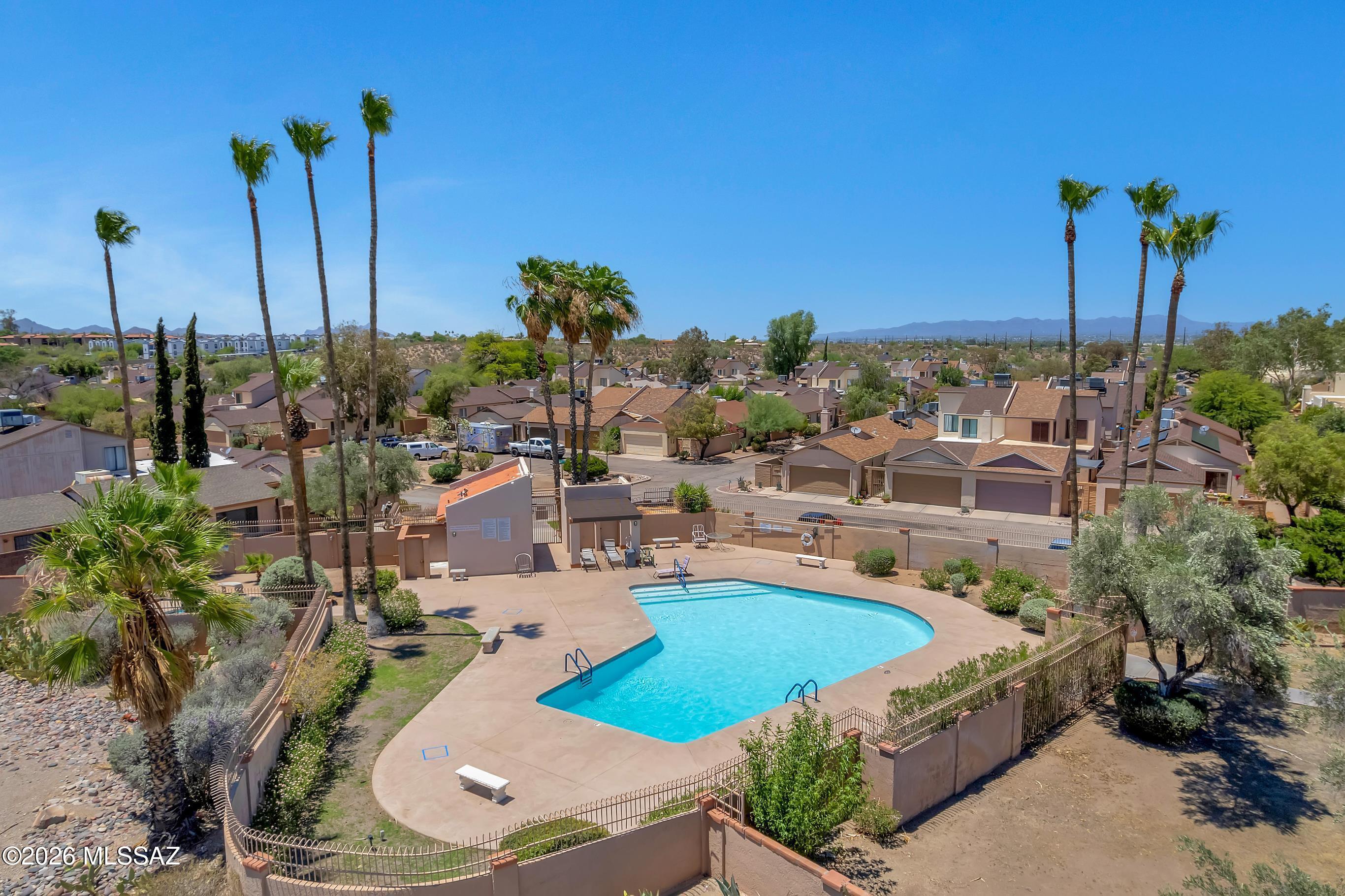 Welcome to this charming single-level townhome nestled in a desirable west Tucson community! Offering 2 bedrooms, 2 bathrooms, and approximately 1,073 square feet of comfortable living space, this thoughtfully designed home features an inviting open floor plan with a cozy fireplace, creating the perfect setting for relaxing or entertaining. The kitchen flows seamlessly into the living and dining areas, while the spacious primary suite offers privacy and comfort. Enjoy low-maintenance living with a private fenced patio--ideal for morning coffee, pets, or evening relaxation. Additional conveniences include covered parking in a gated community and included appliances for an easy move-in experience.  Recent updates include a new air conditioning system and new sliding glass doors, providing enhanced comfort, energy efficiency, and peace of mind.  Residents enjoy access to a resort-style community pool, all while being conveniently located just minutes from Downtown Tucson, the University of Arizona, Pima Community College, I-10, shopping, dining, and outdoor recreation. Whether you're searching for a full-time residence, seasonal getaway, or investment opportunity, this home offers exceptional value in a prime location.