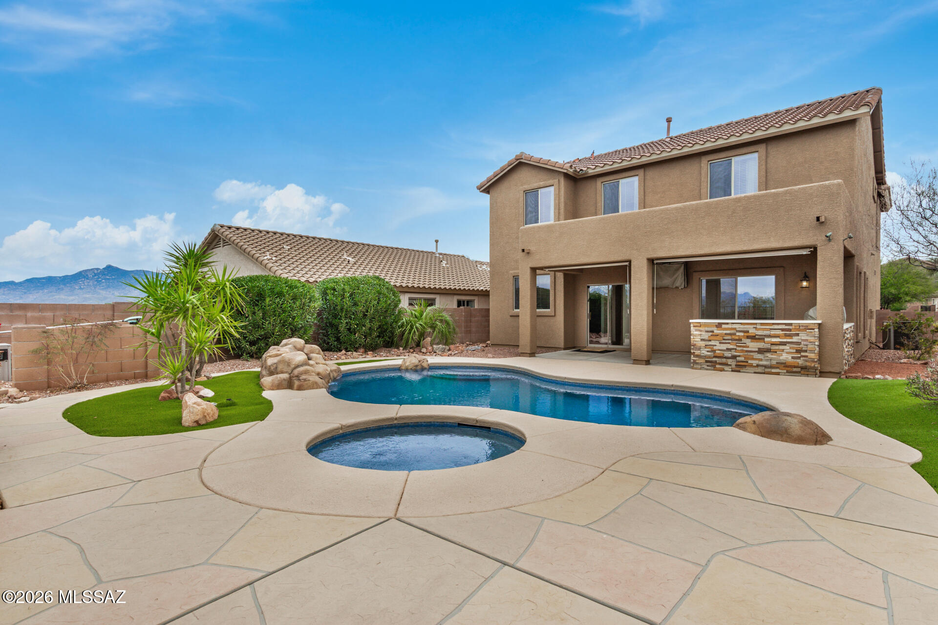 Discover this beautiful two story home with pool in Rancho Del Lago, tucked away in a quiet cul-de-sac with stunning mountain views. The manicured front yard and 2 car garage create inviting curb appeal. Inside, natural light fills the spacious living areas featuring Italian wood grain ceramic flooring, arched passageways, and a warm, neutral palette. The family room fireplace adds cozy charm, while the kitchen showcases quartz countertops, oak cabinetry, tile backsplash, built-in appliances, and a functional peninsula for gathering.

Upstairs, the primary suite offers a walk-in closet and a private ensuite with dual sinks and a quartz shower with glass enclosure. A versatile loft provides the perfect space for a media room, office, or hobby area. Step outside to your backyard retreat with a resurfaced pool deck, upgraded Bluetooth Pentair variable speed pump, multicolor LED pool lighting with 11 light shows, new patio and wraparound walkway, artificial turf, fresh gravel, exterior TV and fan wiring, and a built-in bar and grill, ideal for entertaining. Additional recent updates include interior and exterior paint (2025-2026), replaced windows, new upstairs carpet, epoxy garage flooring, and roof maintenance.

A true move in ready home combining comfort, upgrades, and Arizona outdoor living at its finest.
