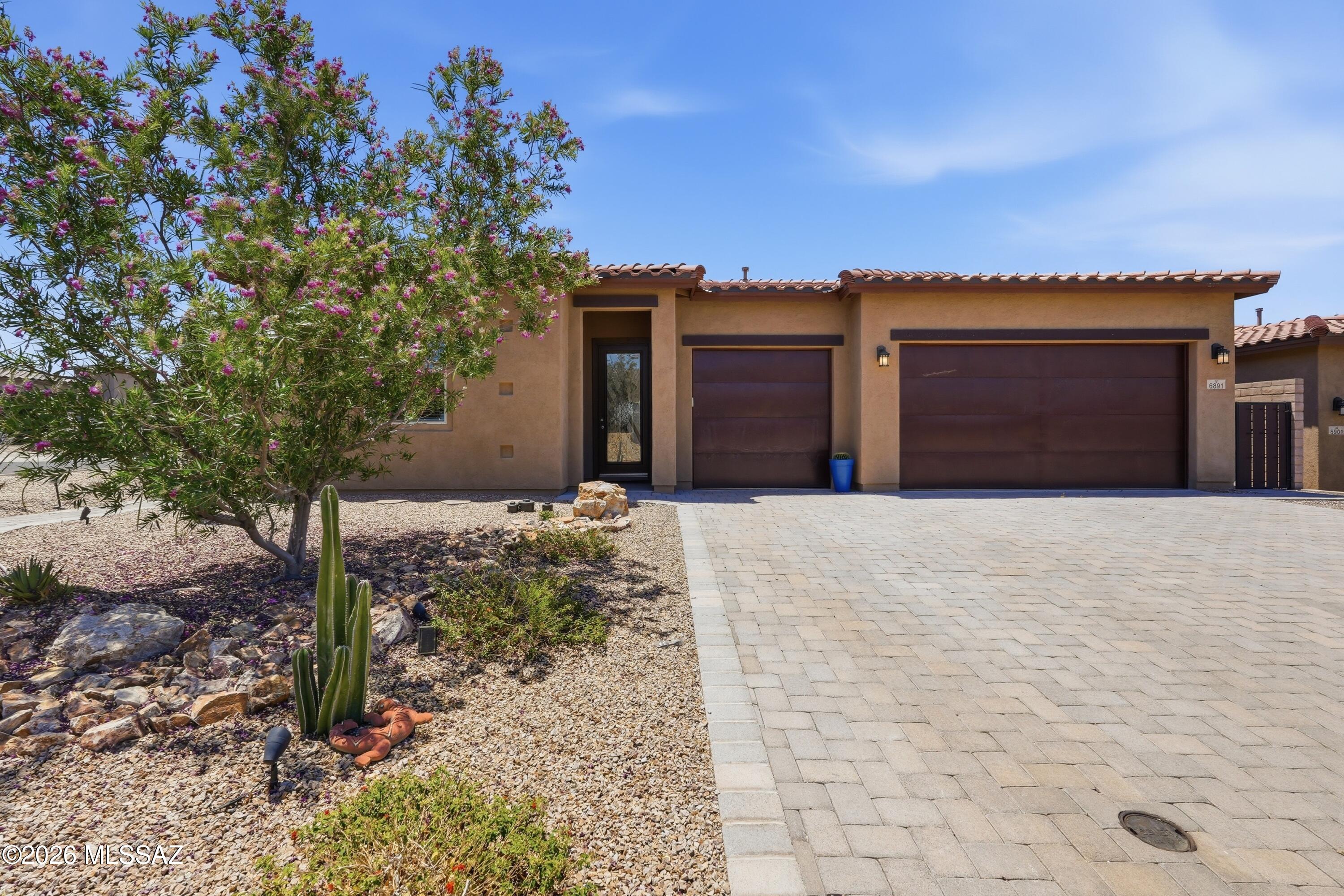 Experience contemporary desert luxury at its absolute finest in this stunning executive estate, perfectly situated on a premium corner lot within the highly coveted gated master plan of Dove Mountain! Built to impress in 2021, this meticulously designed 4BD/3.5BA (2,830 sqft) single-story residence is absolutely packed with high-end designer upgrades, offering a ''better-than-new'' environment tailored for effortless family living and grand weekend hosting. Arrive to find pristine desert views framing both the front and back of the property, creating an immediate connection to Southern Arizona's tranquil natural beauty. Step past the welcoming entrance foyer into a light-filled interior characterized by soaring high ceilings, modern ceramic tile flooring, and double-pane windows that filter in an abundance of natural light. The heart of the home is a massive gourmet chef's kitchen featuring a sprawling central social island, a premium gas cooktop, built-in appliances, a reverse osmosis water filter, and an adjacent den area perfect for a tech center or homework hub. The split-bedroom footprint offers ultimate privacy for everyone. The luxurious primary suite serves as a quiet sanctuary, complete with high ceilings, a massive walk-in closet, and a spa-inspired bath layout. Three additional well-proportioned guest bedrooms and three-and-a-half total bathrooms ensure family and visitors have a comfortable wing of their own. Practical additions like a dedicated laundry room outfitted with a utility sink and integrated storage cabinets, an included home water softener system, and an expansive 3-car garage elevate daily convenience. Outdoor living is pure magic behind the secure block wall fencing. The deep rear covered patio opens to low-maintenance artificial turf and a professionally drip-irrigated tree perimeter--offering a highly private sanctuary perfect for watching Arizona's famous colorful evening sunsets fade into starry night skies. Complete with a neighborhood setting just minutes from the award-winning Dove Mountain CSTEM K-8 School and thousands of acres of premier hiking and championship golf, this turnkey residence delivers an unmatched high-desert lifestyle!