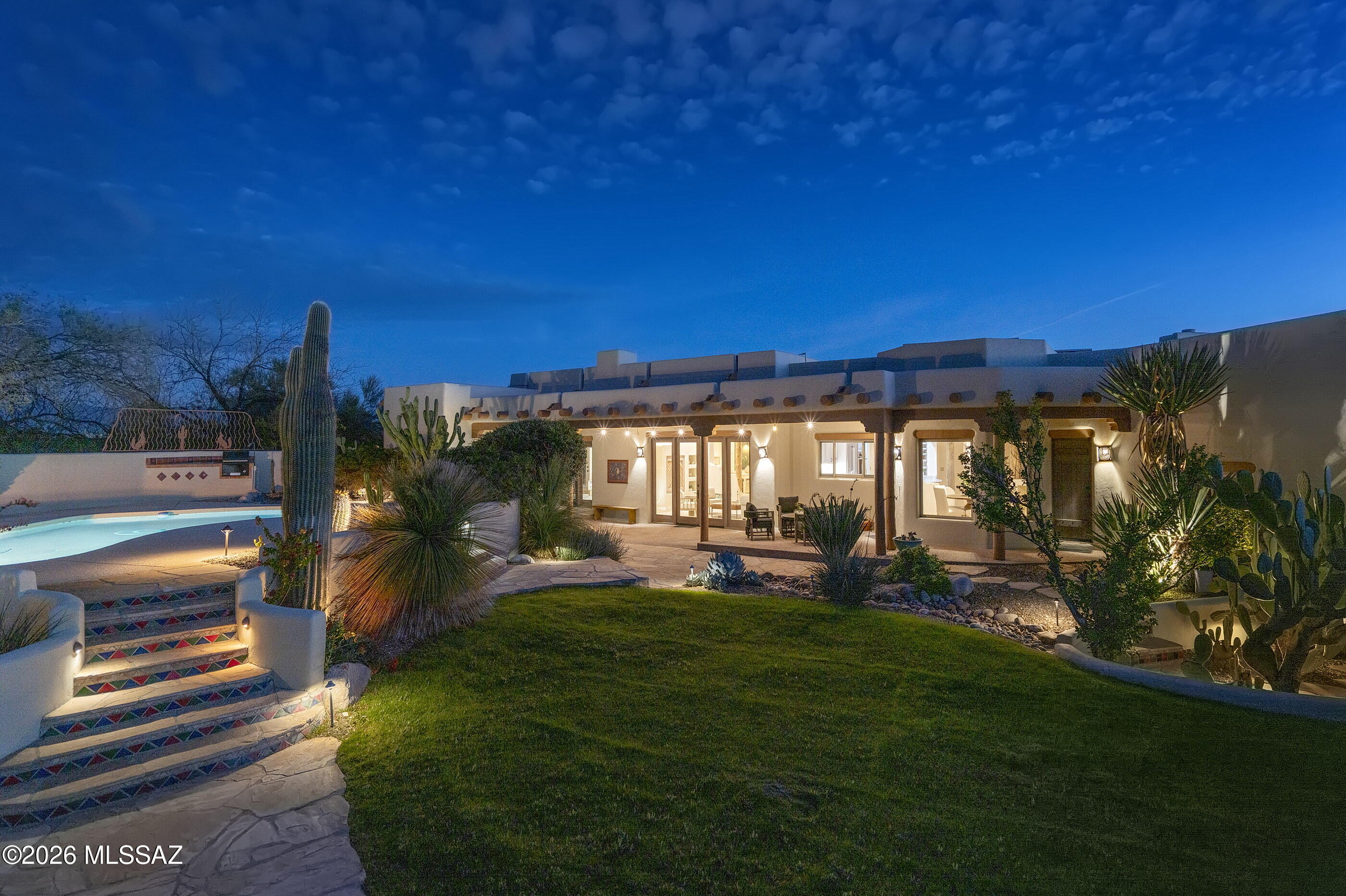 Perched on a hilltop within the gated community of Hacienda del Sol Estates, this stunning Ray Birch designed Santa Fe style home is perfectly positioned to capture breathtaking city lights and sweeping mountain views while offering exceptional privacy on a 1.44 acre lot. The home features an ideal floor plan with 3,629 square feet, 4 bedrooms, 3 bathrooms, plus a dedicated office/den. Light-filled living spaces are perfectly suited for both everyday living and entertaining. Smooth plastered walls, hand-painted tile accents, beehive style masonry fireplaces, and a variety of custom ceiling treatments such as Saguaro-ribbed latillas and Ocotillo ribs with Viga beams, reflect authentic Santa Fe tradition while adding warmth and architectural character. Saltillo tile flooring and rough-sawn cedar Butler doors and cabinetry with Saguaro rib insets further enhance the home's timeless appeal.

The updated kitchen offers granite countertops and stainless steel appliances, and the home has been freshly painted with new carpet throughout. Expansive windows and a seamless indoor-outdoor flow connect the interior to numerous patios, perfect for enjoying Tucson's year-round climate. Outdoor amenities also include a sparkling pool, freestanding hot tub, built-in barbecue, and a large driveway with pavers. 

With its exceptional setting, generous acreage, and panoramic views, this residence offers a rare opportunity to experience refined desert living within convenient proximity to all of life's necessities. From this central Foothills location, one is just moments away from hiking and biking trails, Hacienda Del Sol Resort, La Paloma Country Club and La Encantada's shops and restaurants.