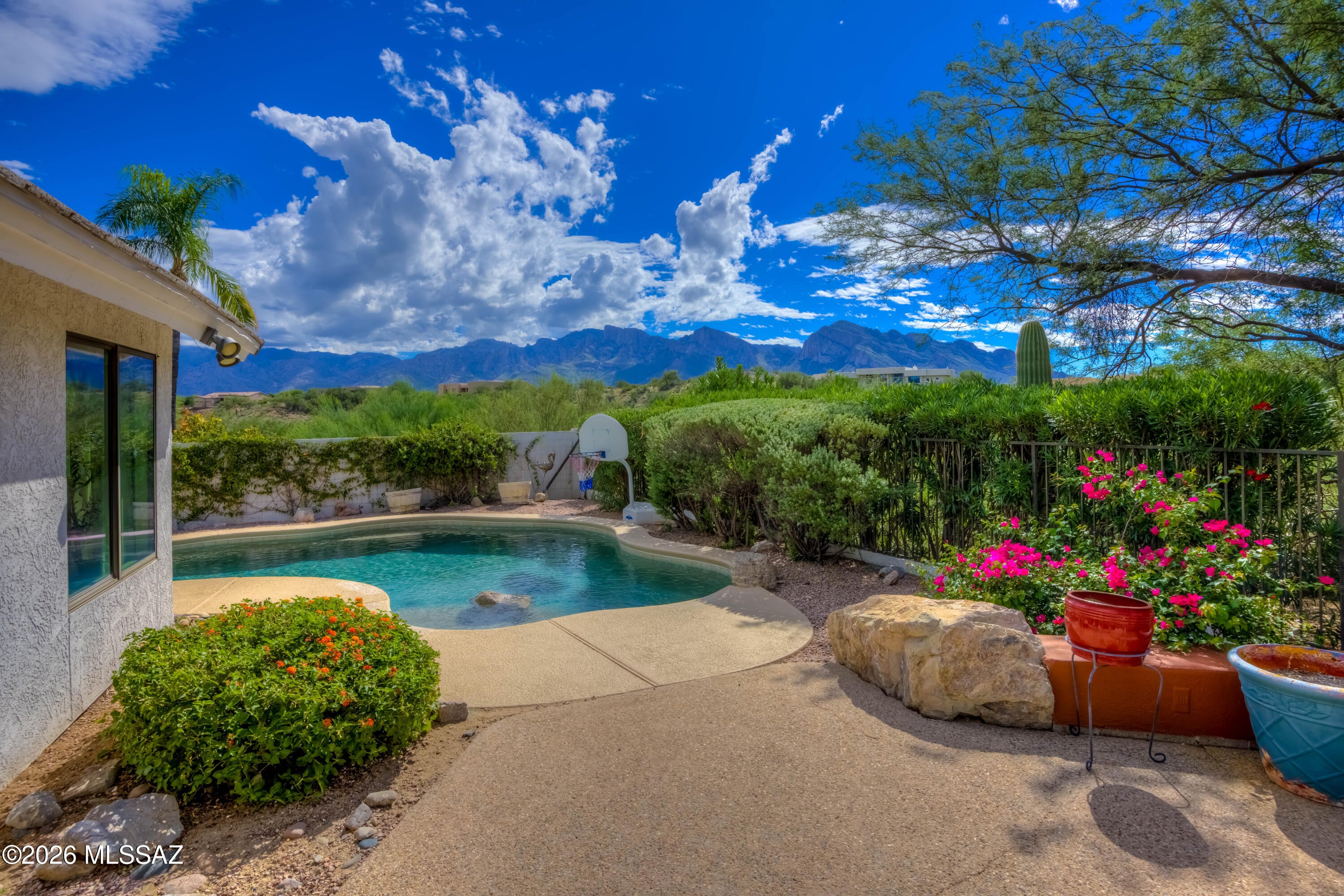 Live beyond expectations in this home with its spacious footprint and gorgeous backyard! The open floorplan allows for great gatherings. Then step outside to a private backyard oasis with a sparkling pool & spa. Sit at the cozy fireplace and take in the unobstructed views of the Catalina Mountains, city lights & stunning sunsets. The covered patio allows for year-round comfort for outside dining or relaxing. Inside, the chef's kitchen impresses with granite counters, stainless finishes, a Thermador range, double ovens, SubZero fridge, freezer drawers, warming drawer, soft-close custom cabinetry & a wine fridge. The primary suite opens directly to the backyard & views for a true retreat feel. A fantastic private office adds versatility, while seamless indoor-outdoor living makes every space shine. This is not just a home it's a lifestyle. Come see it for yourself!