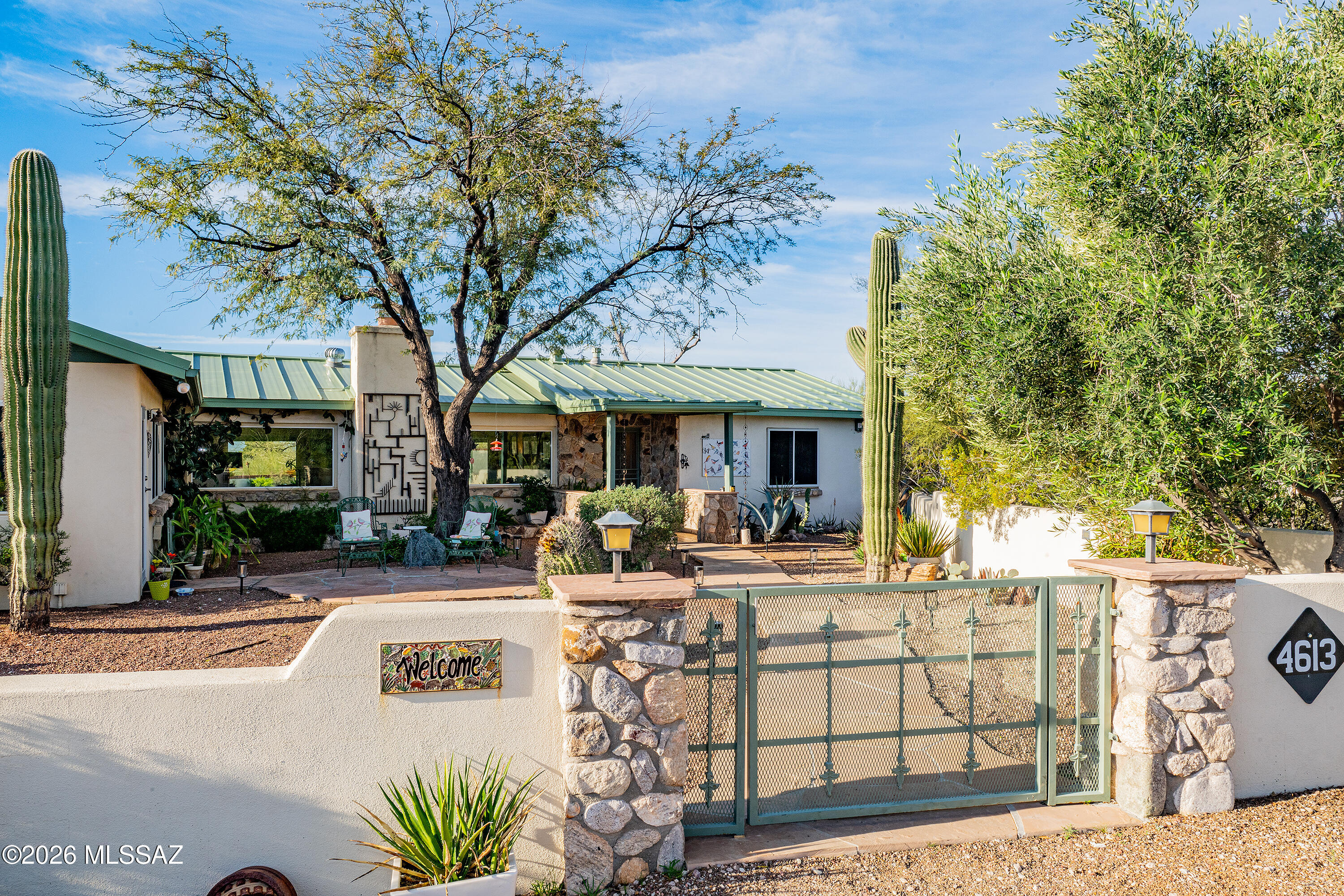 Plenty to see at this property atop a low ridge in the Catalina Foothills: many Saguaros, Santa Catalina Mountains grandeur, city lights, with fabulous sunrises and sunsets, Privacy abounds at the end of a shared driveway. The main house has three bedrooms, two baths, great room, dining room, swimming pool with ramada and
grill area, and a two-car detached garage. The one-bedroom guest house with living room, dining area, bath with laundry and full kitchen, has its own carport and a private patio. Eco features at this address include solar electric panels, solar pool heater, gray water hookups and rainwater harvesting. Walled-in front yards and pool area are perfect for pets. Exceptional desert living yet close to the city! Sunset viewing area & horseshoe pit. Electrical installed for spa