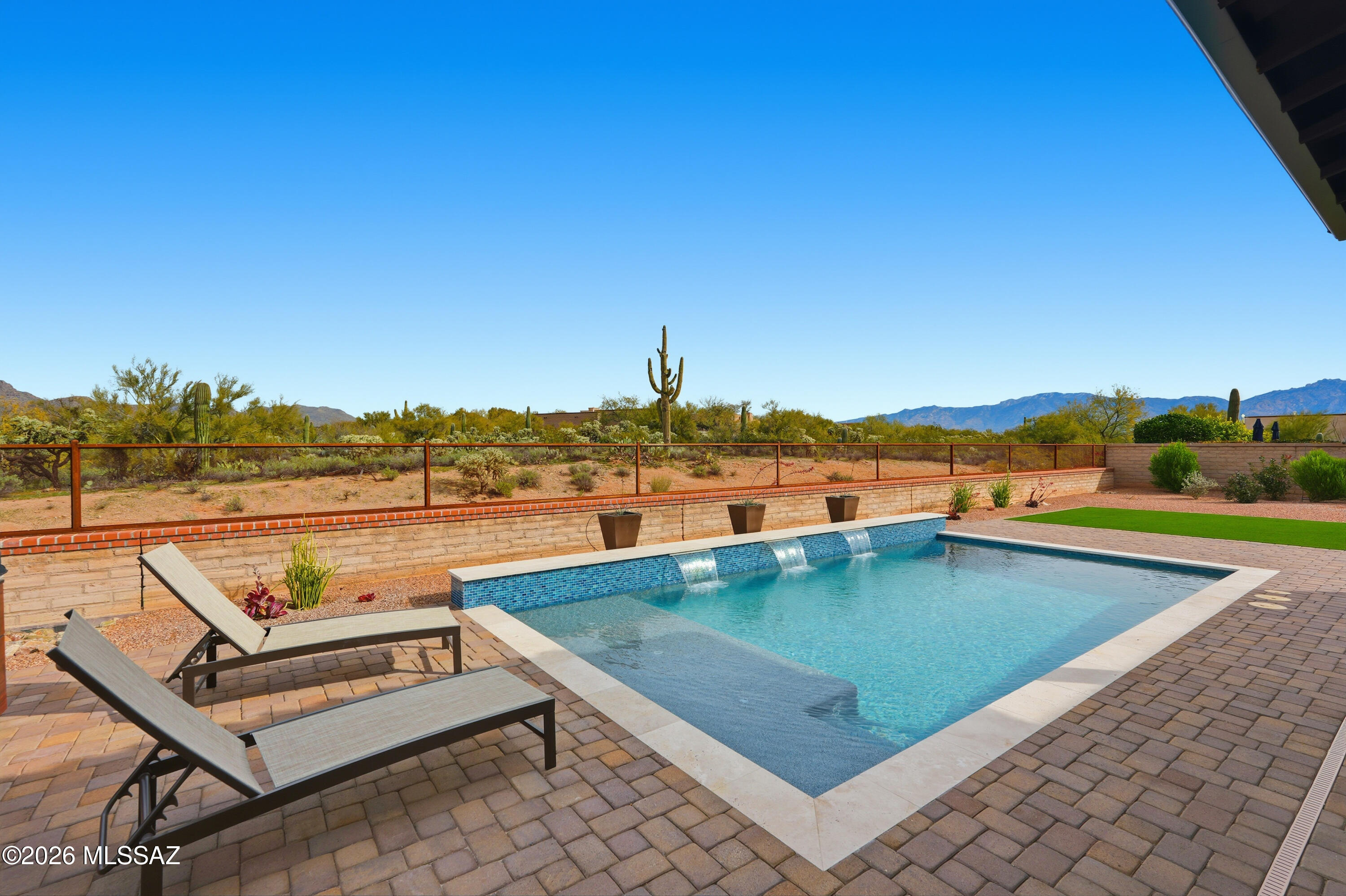 Amazing well maintained custom home located in the prestigious gated community of SKY RANCH. A community nestled within  more than 400 acres of a natural reserve. This  home offers quality craftsmanship and pride of ownership. It sits on an oversized lot, originally two lots, with incredible views of the open desert and Tortolita mountains. There is beautiful new in-ground pool that gives you that desert resort feeling as you look over the pool through the natural desert at the mountains. Split bedroom plan, SS appliances, high end  interior finished, polished concrete floors, Alder cabinets and adobe accents.