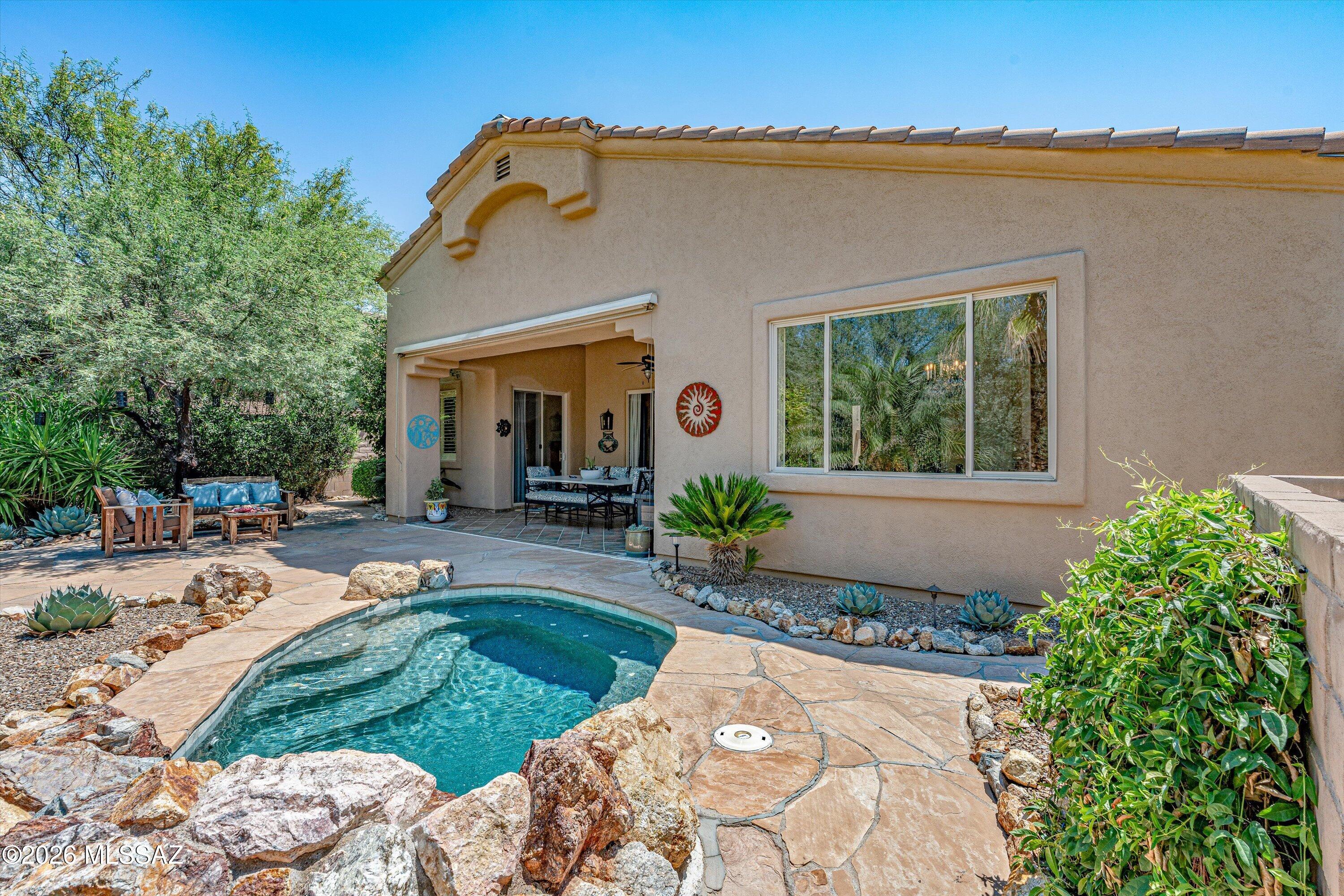 Tucked into a beautifully landscaped setting with Catalina Mountain views, this 3 bedroom, 2 bath home with a separate den offers the indoor/outdoor lifestyle Tucson does best. High ceilings, natural light & tile flooring create an inviting interior. The living room features a fireplace with built in shelving & flows into the dining area & updated kitchen with granite counters, stainless appliances, gas cooktop & microwave & wall oven. The spacious primary suite offers patio access, dual vanities, soaking tub & separate shower. Outside, enjoy a private backyard retreat with a sparkling pool, rock waterfall, mature landscaping & covered patio. Located in gated Sabino Springs, home to Arizona National Golf Club.