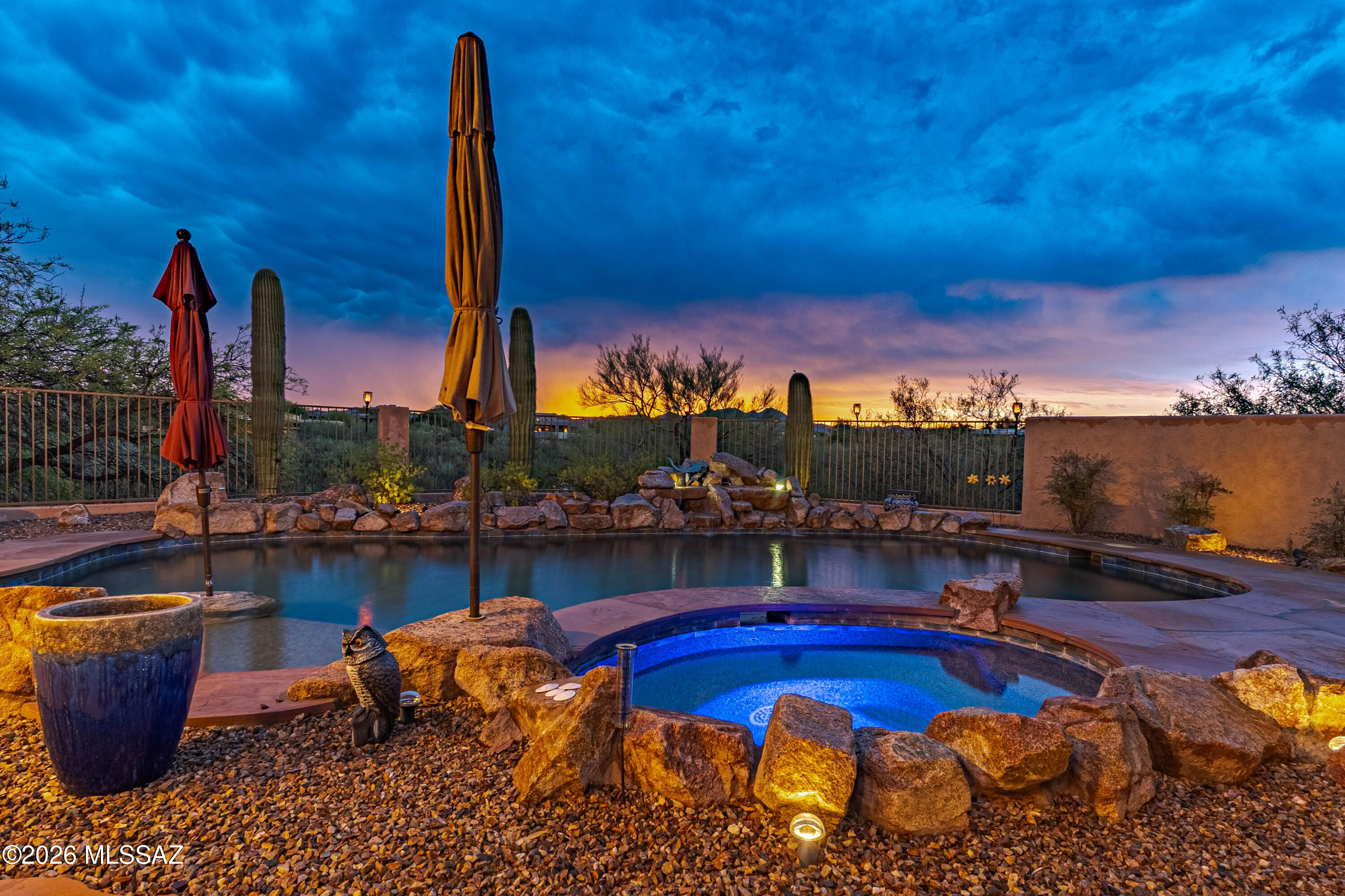 A private desert resort with breathtaking mountain views--this exceptional Coyote Ridge residence delivers the best of Oro Valley living. Set at the end of a secluded 1.01-acre cul-de-sac lot in a prestigious gated community, this 3,666-square-foot single-story home offers 4 oversized bedrooms, 4 full bathrooms, an oversized 4-car garage, and stunning views from nearly every window. Designed for effortless Arizona living and entertaining, the open-concept split floor plan features soaring ceilings, abundant natural light, no interior steps, energy-efficient Nudura construction, a newer roof, and beautiful travertine flooring throughout most of the home. The gourmet kitchen boasts granite countertops, an oversized island, extensive pull-out cabinetry, walk-in pantry, built-in desk, and premium stainless-steel appliances, including double ovens, gas cooktop, range hood, and newer Bosch dishwasher. Enjoy views of the private courtyard from your relaxing kitchen nook. The spacious carpeted primary suite is a private retreat with backyard access, a spa-inspired jetted tub, and an oversized custom walk-in closet. Two additional ensuite carpeted bedrooms offer exceptional privacy and comfort for family or guests, with walk-in closets in every bedroom. The tiled fourth bedroom is adjacent to an additional full bathroom/powder room. An oversized laundry room, water softener, polyaspartic-coated garage floor, and most furnishings available to convey add convenience and value. Step outside and experience your own private resort, complete with a sparkling pool, rock waterfall, jetted spa, expansive covered flagstone patio with misters, built-in barbecue, and panoramic mountain views. Ideally located near parks, trails, and schools, this extraordinary Oro Valley property offers rare privacy, resort-style amenities, and the quintessential Arizona lifestyle--all in one exceptional home.