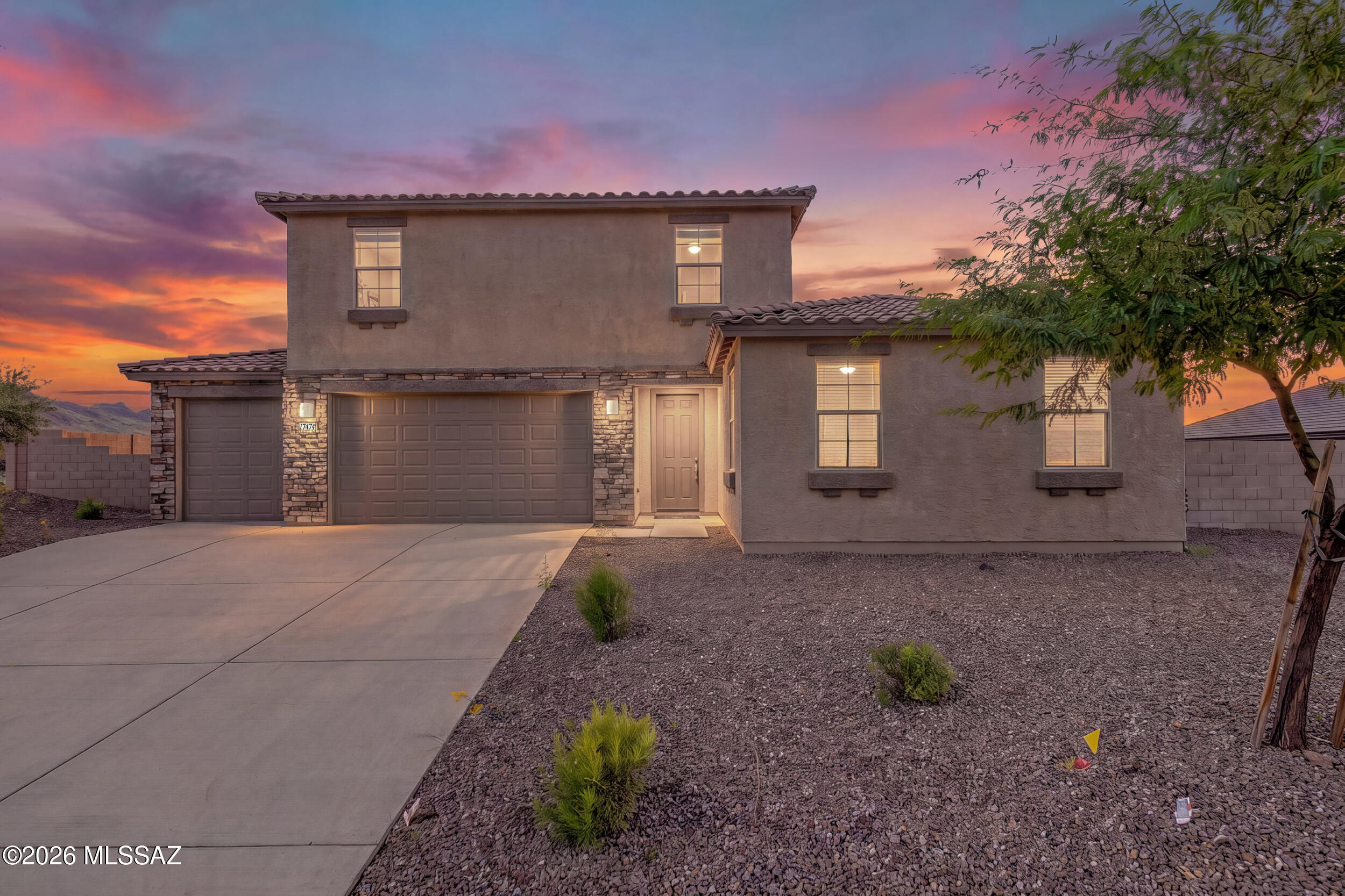 Multigenerational home with NextGen suite in Southern Arizona! This 2023 Lennar former model home offers 5 bedrooms, 3.5 bathrooms, a 4 car garage, and no neighbors behind you. The NextGen suite includes a private entrance, kitchenette, bedroom, full bathroom, and laundry room, so everyone has their own space. The main kitchen has a large breakfast bar island with storage, granite countertops, stainless steel appliances, and custom cabinetry. Ceramic tile covers the living spaces, bedrooms have carpet, and each bathroom has modern fixtures. The backyard is fully finished with pavers, artificial turf, decorative gravel, mature trees, and a patio for evening sunsets. Room for family, guests, cars, and toys, all in one Lennar NextGen model home!