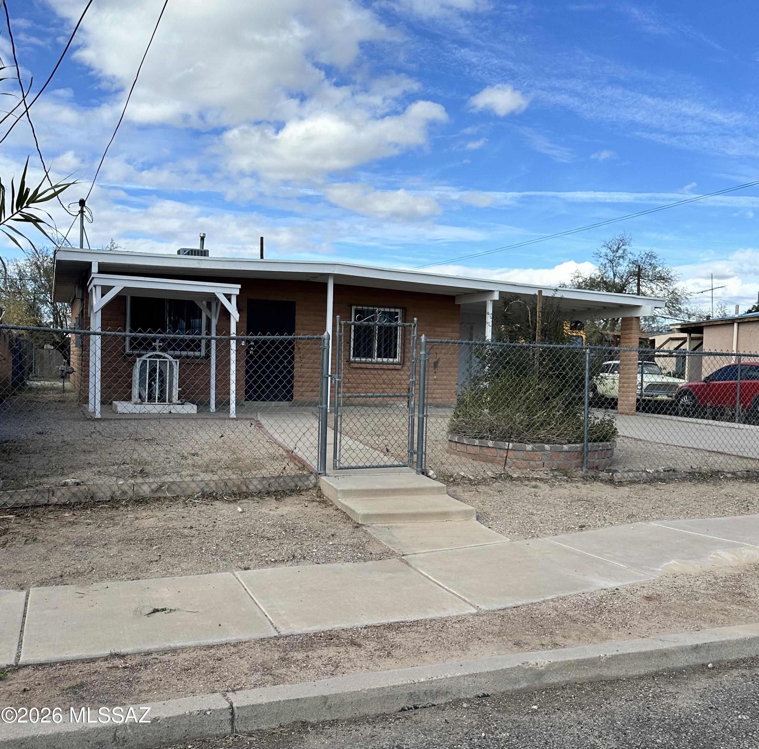 Charming 2 bedroom, 1 bath home in a historic Tucson neighborhood with quick freeway access and central location. Solid brick construction with custom dual-pane windows and security bars throughout. Updated bathroom with tiled walk-in shower, tile flooring in main living areas, and spacious kitchen ready for your personal touch. New HVAC and water heater (2018). Separate laundry room, covered carport, detached storage shed, and fully fenced front and backyard with plenty of space to expand or customize. Great opportunity for owner-occupant or investor. Property sold as-is.