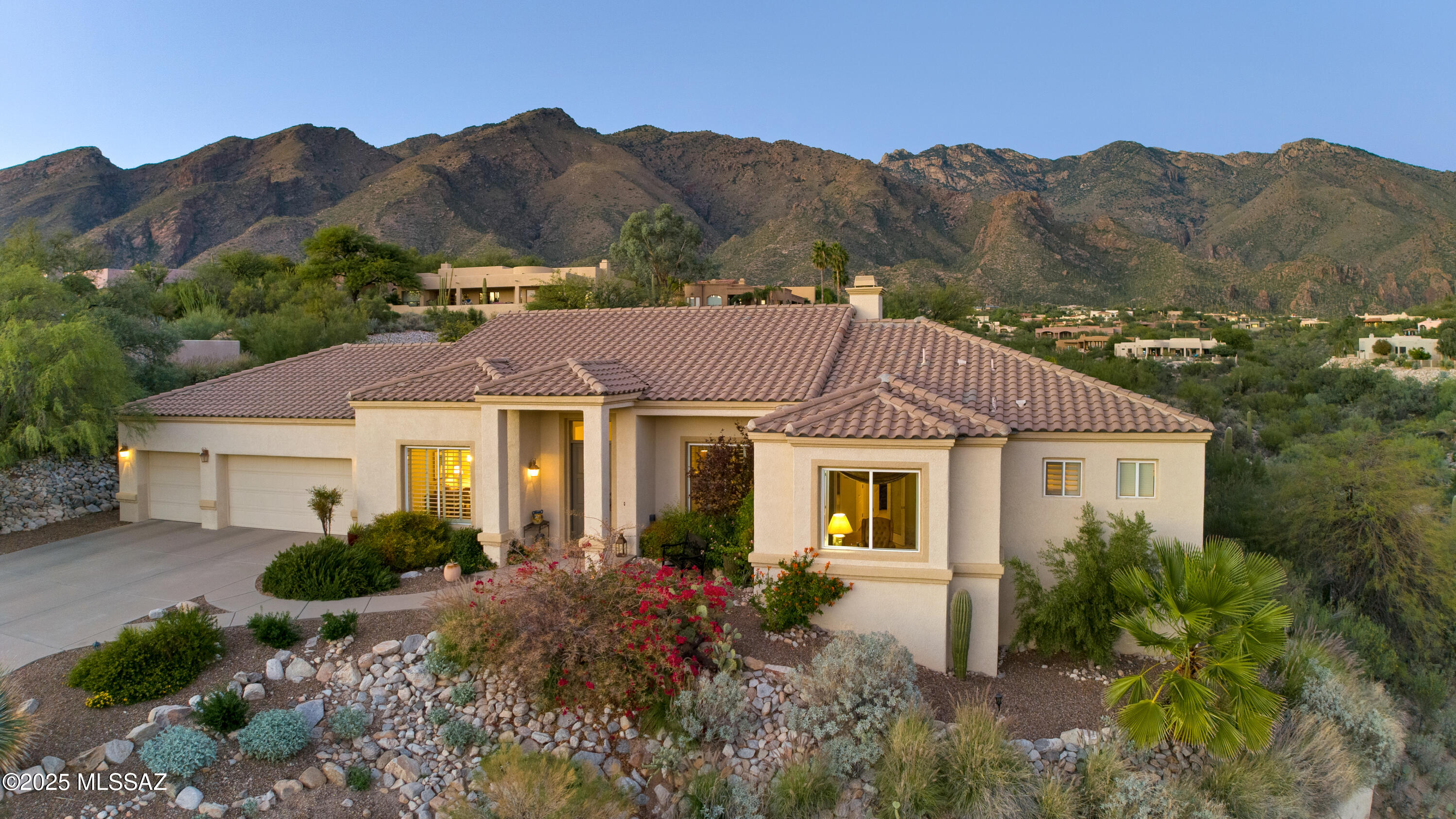 Privately set on an elevated half-acre lot in a quiet cul-de-sac within desirable Alta Vista Estates, this pristine masonry-built custom residence offers exceptional mountain and city views. Ideally located in the foothills just minutes from Ventana Canyon Country Club. Recent updates include a brand-new tile roof (2025) and a replaced HVAC system. Elegant, timeless, and meticulously maintained, the single-level design with no interior steps is ideal for effortless lock-and-leave living. High ceilings, north/south exposure, and abundant windows and skylights create a light-filled interior. Warm Saltillo tile floors—recently cleaned & resealed—anchor the living spaces, while the inviting living room features a fireplace &  expansive windows capturing unobstructed mountain views. Cont'd. The formal dining room is ideal for both large-scale entertaining & intimate dinner parties. Plantation shutters throughout the home elevate the design, providing both form & function. The split-bedroom layout includes two spacious master suites, each with dual-sink vanities, patio access, &  oversized walk-in closets. One master suite has a soaking tub with exceptional mountain views.  A third bedroom and bath, ideal for guests, an office, or flex space, offers city views. A generously sized laundry room with extensive cabinetry and a utility sink provides extra storage.

Outdoors, the beautifully landscaped backyard is serene and low maintenance, featuring mature vegetation, fruit trees, a deep covered ceramic-tile patio, a built-in BBQ, and a private gate that leads to walking trails.  Backing to an HOA common-area greenbelt, the property enjoys exceptional privacy and a peaceful buffer.  Watch the sunrise over the Catalina Mountains with a direct view of the saguaro-studded mountains & Ventana Canyon in the morning, then watch it descend over the Tucson Mountains as it lights the western sky with sensational colors. No pool means minimal upkeep and true ease of ownership.
Located within five minutes of world-class golf resorts & the best of Tucson shopping, dining, & more. Minutes from Whole Foods, Sabino Canyon Recreation Area, Ventana Canyon Resort & Country Club, Ventana Canyon Trailhead that connects with endless trails in the Catalina Mountains. Easy access to La Encantada Shopping Mall &  "The Loop"- Tucson's  133-mile connected bike path. Highly-rated District #16 schools with the Ventana Vista Elementary School Spanish Immersion program.
