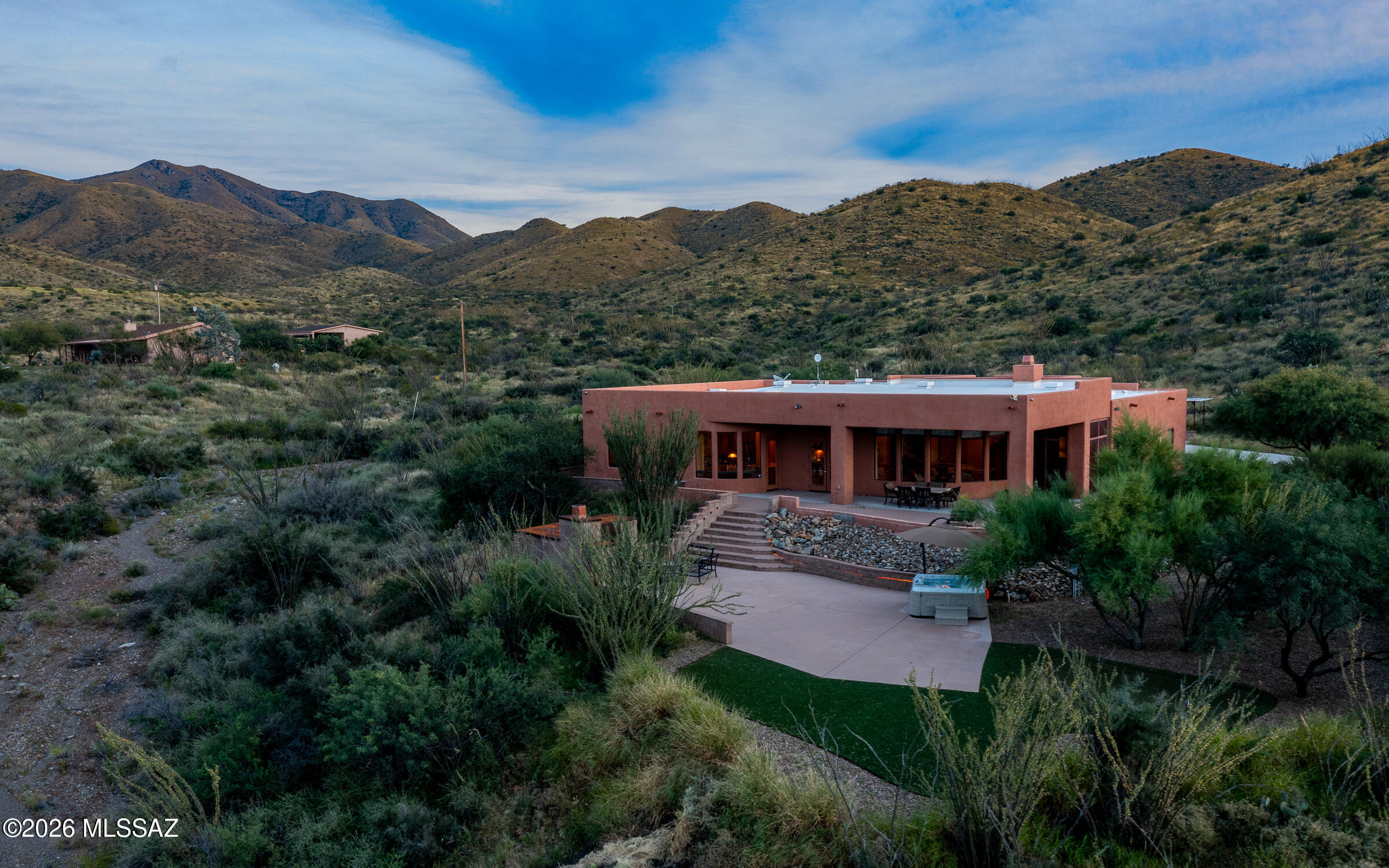 Secluded & nestled in the Santa Rita Mountains with panoramic views sits this beautiful Ducati Custom built home on 4.15 sprawling acres of lush natural desert landscape. The long extended driveway leads to a screened-in courtyard that opens to a well thought-out & spacious floor plan. Natural stone flooring on a French layout pattern, hand carved mesquite mantle over the warming fireplace, formal dining room with built-in buffet cabinets & wide open kitchen are just a few of the special features. Master suite is large with dual vanities, closets & a private screened-in porch. Popular media room with its own personal patio provides a great space for all your entertaining needs. Retreat outdoors to the relaxing hot tub, colorful sunsets & a cozy fireplace for those winter nights.