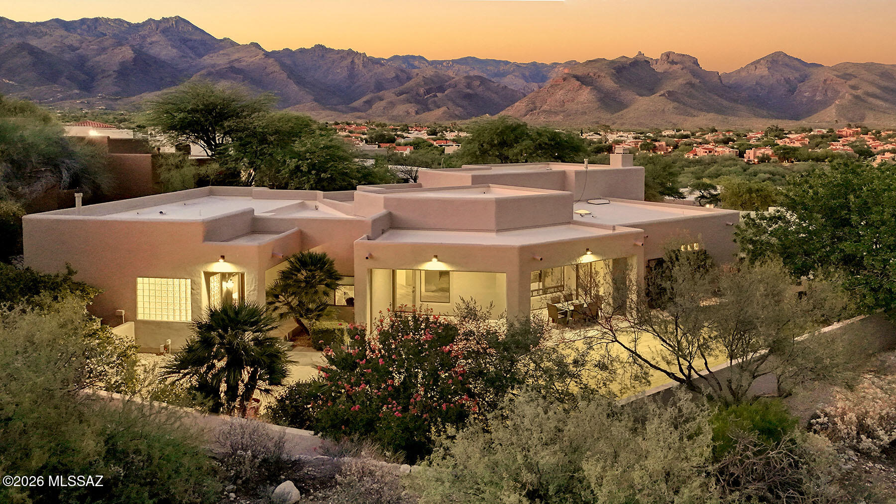 Located in the prestigious gated Ventana Ridge community, this 3,487 sq. ft. home offers stunning Catalina Mountain views from the front and Rincon views from the back. Set on .43 acres, the beautifully landscaped property features a walled backyard with natural grass, fruit trees, multiple saguaros, and an extended covered flagstone patio with several seating areas. Inside are 4 bedrooms, 2.5 baths, formal living and dining rooms, and a raised family room with a gas fireplace and view balcony. The spacious kitchen boasts granite countertops, double ovens, gas cooktop, walk-in pantry, and mountain views. Smart home technology, built-in speakers, a tandem 3-car garage, and a luxurious primary suite with patio access complete this exceptional home near Sabino Canyon, hiking, and dining.