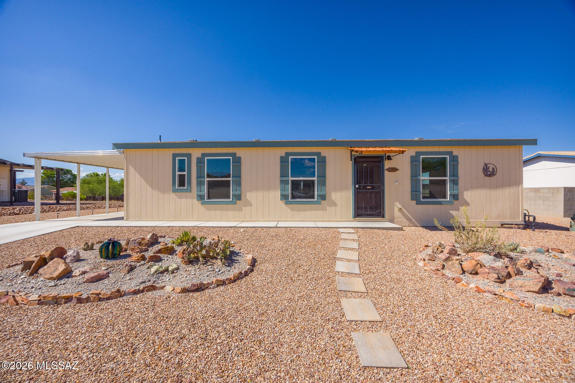 This like-new ground-set manufactured home offers comfortable living with exceptional features inside and out. Featuring a bright 2-bed, 2-bath layout, the home is equipped with a premium Life Source water system for clean, quality water throughout. Step outside to enjoy immaculate, low-maintenance landscaping in both the front and fully fenced backyard, offering plenty of privacy and outdoor enjoyment. Parking and storage are effortless with two spacious carports and a convenient storage shed on-site. Ideally located in a friendly neighborhood, you'll be just minutes from local amenities, shopping, dining, and top-rated schools. Beautifully maintained and completely move-in ready--this charming turn-key residence offers a perfect blend of convenience, style, and peace of mind!