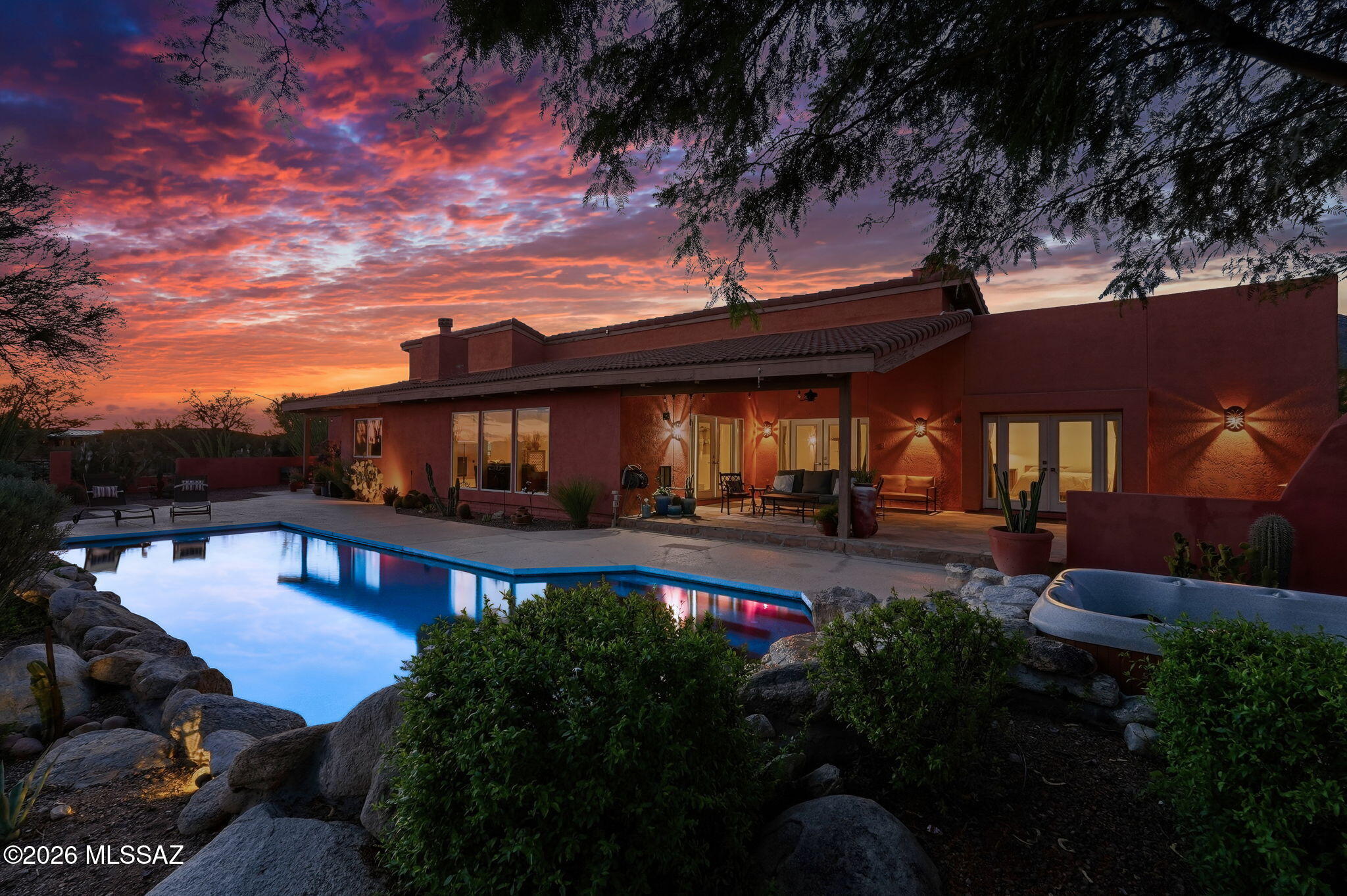 Enjoy the best of the Arizona lifestyle in this thoughtfully designed Foothills home, where mountain and city views, beautiful desert surroundings, and a peaceful setting meet everyday convenience. Spend sunny afternoons by the sparkling pool and natural rock waterfall, gather around the outdoor fireplace, or unwind on the many patios with space to entertain and relax. Enjoy outdoor dining while sunrise and sunset views provide a stunning backdrop. Inside, soaring ceilings and a double-sided fireplace create a warm atmosphere, complemented by a gourmet kitchen with a generous center island, oversized refrigerator and freezer, and abundant cabinetry. Ideally located near shopping, dining, and hiking, this home also features a three-car garage and the perfect blend of comfort and privacy.