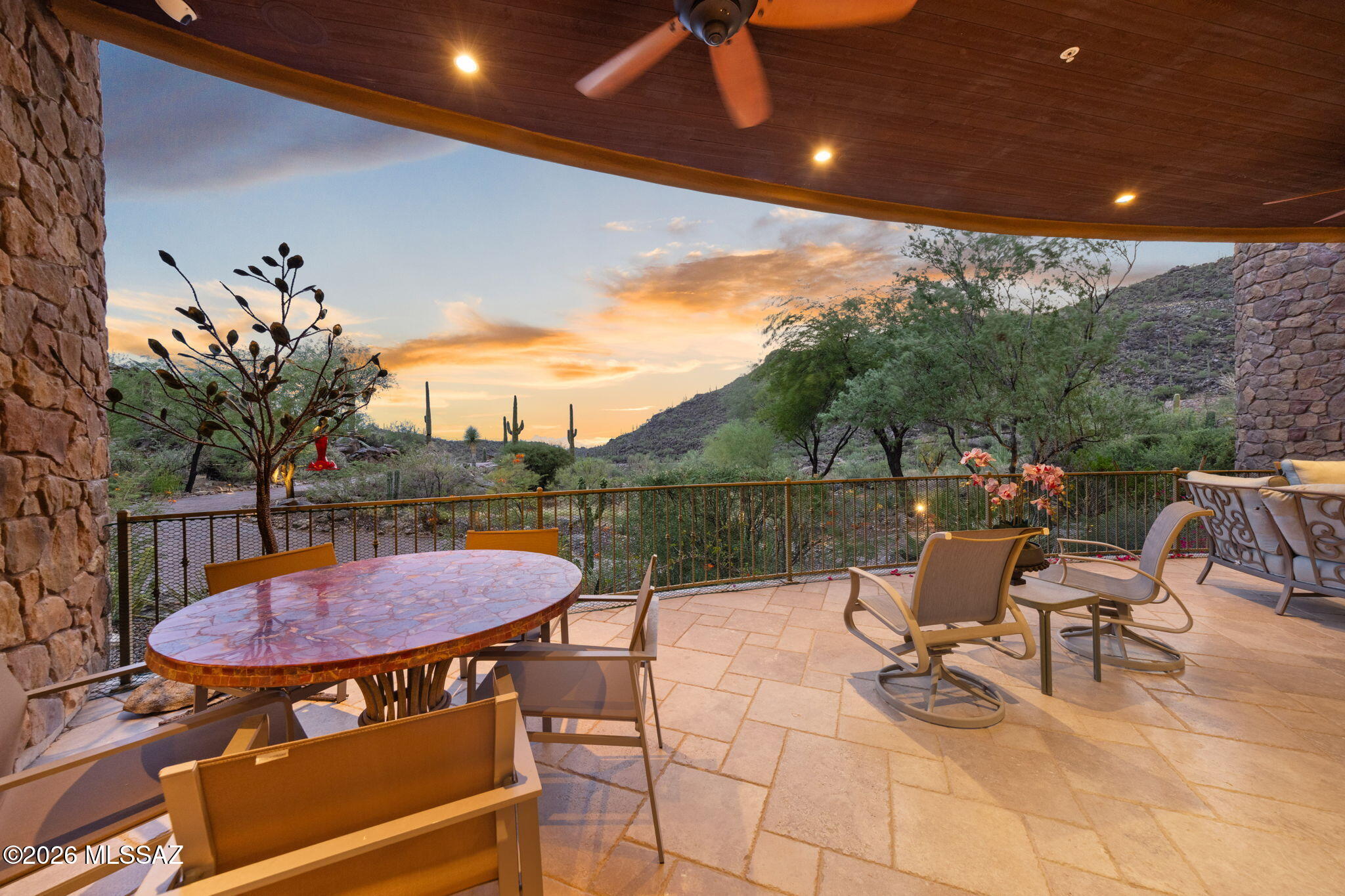 Hidden beyond Saguaro Ranch's iconic stone tunnel, every arrival feels like an escape. Perched atop 4.75 private acres at the end of a secluded cul-de-sac, this semi-furnished Ron Robinette-designed estate commands sweeping mountain vistas, city lights, and unforgettable Arizona sunsets. Walls of glass and effortless indoor-outdoor living create a setting for grand entertaining and quiet evenings above it all. Complete with a private guest house and exceptional privacy, the estate is just 10-15 minutes from world-class golf at Stone Canyon and Dove Mountain.