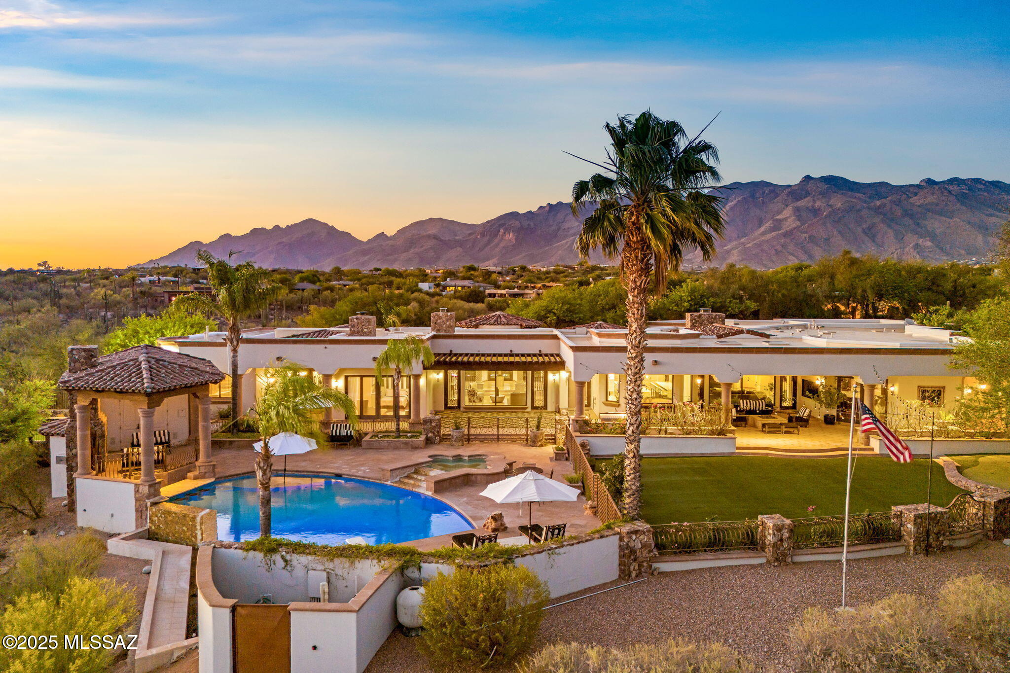 Exuding timeless sophistication and refined elegance, this 2.84-acre luxury estate in the heart of Catalina Foothills Estates #10, redefines classic Spanish architecture with unparalleled craftsmanship. A former ''Home of the Year'' recipient, this masterpiece offers ultimate privacy within a double-gated enclave, featuring a 24-hour manned community guard gate and a striking artistic iron gate at the property entrance. The main house encompasses 5 bedrooms, 4 with ensuite bathrooms, a custom bar/recreation room, a dedicated office/library, and a playroom/sitting room. A detached guest house offers a private entrance, 1 bedroom, 1 full bathroom, a kitchenette, and a cozy fireplace ideal for multi-generational living. The oversized 4 car garage ensures plenty of storage space for car and hobby enthusiasts. 

Rarely will you find such meticulously curated grounds that are this perfect for entertaining. The showstopper is the heated infinity-edge pool that spills over into panoramic city views clear to downtown. The pool also features a swim-up bar with built-in seating, a baja shelf with umbrella stand, and a spacious spa with waterfall feature. Relax in the shade in one of the multiple covered patios which includes a large gas fire pit and a built-in Viking BBQ. Enjoy the sunsets from the custom-built ramada with a rock fireplace and its own pool bath. The backyard features an expansive artificial turf area that can host the largest of gatherings, as well as a golf putting green The separate dedicated play area with a trampoline and basketball hoop elevate this backyard to an unparalleled retreat. 

Making a striking first impression as you enter this exquisite property, you're greeted by a circular paver driveway guiding you to a breathtaking gated front courtyard. This serene oasis features a stunning water feature, tranquil fountains, and lush landscaping, leading to an elegant custom glass and wrought iron front door.

Inside, no detail was spared, starting with the grand foyer that encompasses a balance of timeless natural stones, leading to a great room with an intricate custom fireplace. The newly remodeled modern gourmet chef's kitchen dazzles with quartz countertops, large double islands with waterfall edges and double sinks, a Sub-Zero refrigerator and freezer, a Wolf 6-burner gas range with double ovens, a built-in Miele coffee system, double Cove dishwashers, modern pendant and under-cabinet lighting, and a walk-in pantry with shelving. The newly remodeled breakfast nook is the favorite gathering spot for meals with new custom banquette seating. A custom climate-controlled wine cellar adds sophistication. The luxurious primary bedroom features a large seating area with its own fireplace and two sets of wrought iron French doors, while the spacious primary bathroom offers dual vanities, a walk-in shower, a large tub with fireplace, and a spacious walk-in closet with custom cabinetry and large island.

This extraordinary estate seamlessly blends masterfully designed interiors with resort-style outdoor living, offering an unrivaled lifestyle of elegance and exclusivity in one of Tucson's most prestigious communities.
