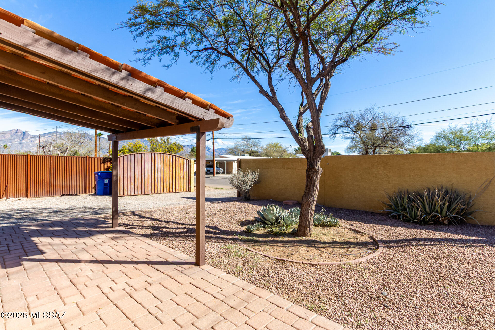 Masonry built ranch style bungalow - 2-bedroom home, complete with Owned Solar Panels for added energy savings and the Premises is Completely Walled! Upon arrival, you'll appreciate the wide RV gate (electric), carport parking, & a welcoming front patio where you can take in amazing mountain views. Inside, sunlight pours into every corner. Inviting open floor plan is enhanced by a stove fireplace, while the sizable family room showcases exposed ceiling beams. Custom palette, Saltillo tile flooring, & skylights further elevate the house's warmth & appeal. The kitchen features SS appliances, abundant cabinetry, & solid-surface counters. Each bedroom ensures a comfortable space for a good night's sleep. Spacious backyard has a covered patio, perfect for relaxing. Quiet, mature, affordable area in Central Tucson.  Close to hospitals, groceries, schools, restaurants, shopping, bike and walking paths.