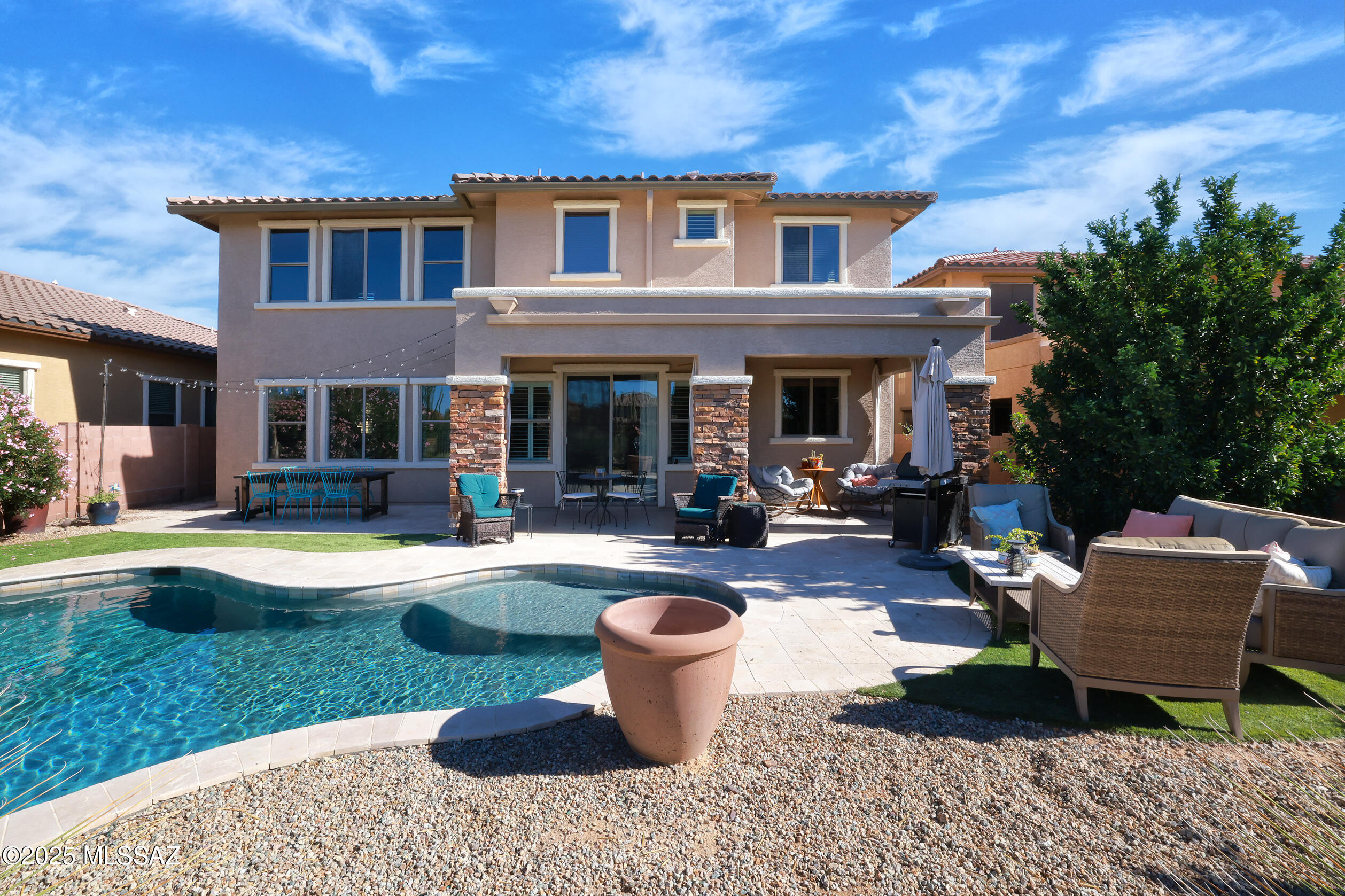 Outstanding 5 bedroom, 3 bath home in gated Tangerine Crossing. There's nothing missing here! Courtyard entry leads to custom metal door, then behold the two-story foyer. WOW! Spacious, light-filled living areas are open, yet feel classic. Spectacular two-sided stacked-stone fireplace is a focal point, separating what can be formal dining or flex space. Excellent island kitchen with loads of storage, workspace & nice SS appliances., open to living & casual dining area.  1st floor 5th bedroom/den/office and full Bath. Upstairs features  a large luxurious landing, covered deck and 4 bedrooms. Primary suite is huge w/ fab walk-in closets. Beautiful backyard has vacation vibes, new pool, mountain & sunset views, nice landscape & privacy. Three-car garage, too
