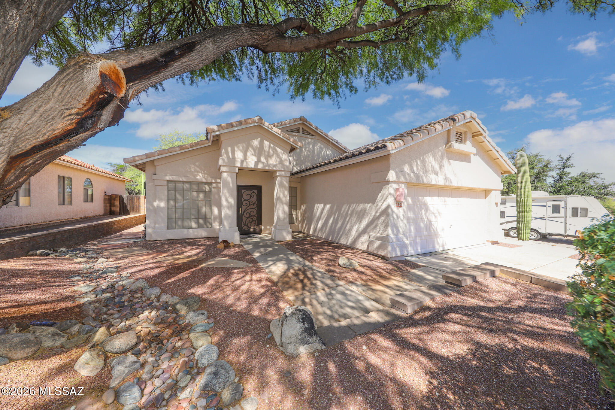 Tucked away on a quiet cul-de-sac, this well maintained 4 bed 2 bath home with vaulted ceilings offers a desirable split floorplan with generous living spaces and thoughtfully designed indoor-outdoor living. The large open kitchen with breakfast nook flows seamlessly into one of two spacious living areas highlighted by a cozy fireplace with a striking flagstone hearth. Quality finishes can be found throughout including Silestone, Royalstone and Swanstone countertops. Professionally designed backyard is an ideal retreat with Kiva fireplace, small lawn, covered patio with remote controlled rolling screens and view fencing overlooking a serene desert common area for added privacy and natural beauty. Discover the perfect balance of comfort, privacy and stunning AZ desert living you deserve!