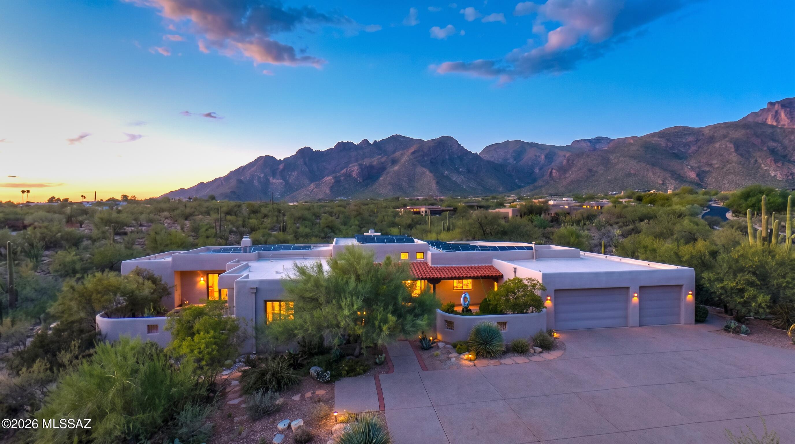 Enjoy stunning mountain view, spectacular sunrises and sunset, and the peaceful park-like setting of Pima Canyon. Thoughtfully designed by architect Steve Bohn, this distinctive home features dramatic varying ceiling heights, beautiful wood details, graceful arches, pocket doors, a magnificent entry and carefully positioned windows and skylights that fill the home with natural light while moderating the desert sun. The 14-foot ceiling living room centers the home, highlighted  by fireplace and custom mesquite mantle. Spacious indoor-outdoor living  includes an inviting back porch front courtyard enclosed garden and artistic touches throughout. A serene and elegant Tucson retreat designed for comfortable living and entertaining. 4 Br, 4ba, 3474 Sqft. 3 Car Garage, quiet 1.2 acres.