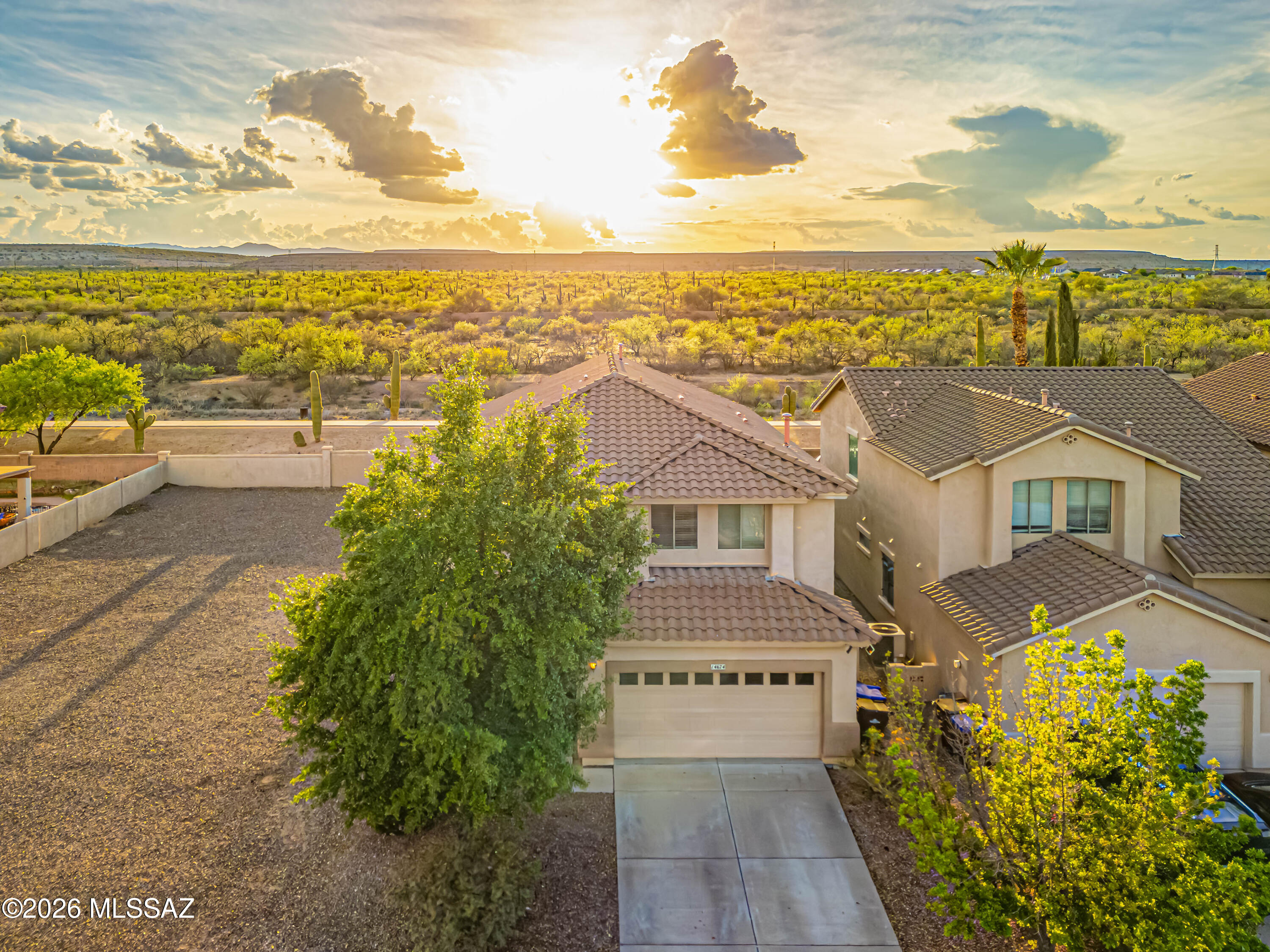 Beautifully updated home featuring the highly sought-after Saguaro floor plan, on a desirable lot with only one adjacent neighbor!  This 2,830 sqft residence offers 4 generously sized bedrooms, 3 full bathrooms, and a 2-car garage with built-in storage.  Set on a premium lot, enjoy exceptional privacy with NO ONE BEHIND and an adjacent VACANT LOT to the south!  Inside, the home boasts three distinct living areas, including separate living and family rooms downstairs, plus a versatile loft upstairs for home office, media room, or play space.  The kitchen offers abundant counter space and includes all appliances. Entertainer's backyard boasts a large covered patio, firepit, pergola, paver accents, artificial turf, garden beds, two storage sheds, landscape lighting, mature lemon and tangerine trees, and even greenhouses (removable upon request).  Upstairs, you'll find three spacious bedrooms and two full bathrooms, along with a conveniently located laundry area. The expansive primary suite features a massive walk-in closet and a luxurious bathroom with dual vanities, a soaking tub, separate shower, private water closet, and updated lighting. A fourth bedroom and full bath on the main level provide flexibility for guests or multi-generational living.  Updated flooring throughout, including travertine, tile, and luxury vinyl plank!  Cat 5 wiring in all bedrooms!  Walking distance to Sahuarita Lake Park and Community Center!  This home combines space, functionality, and an unbeatable setting!