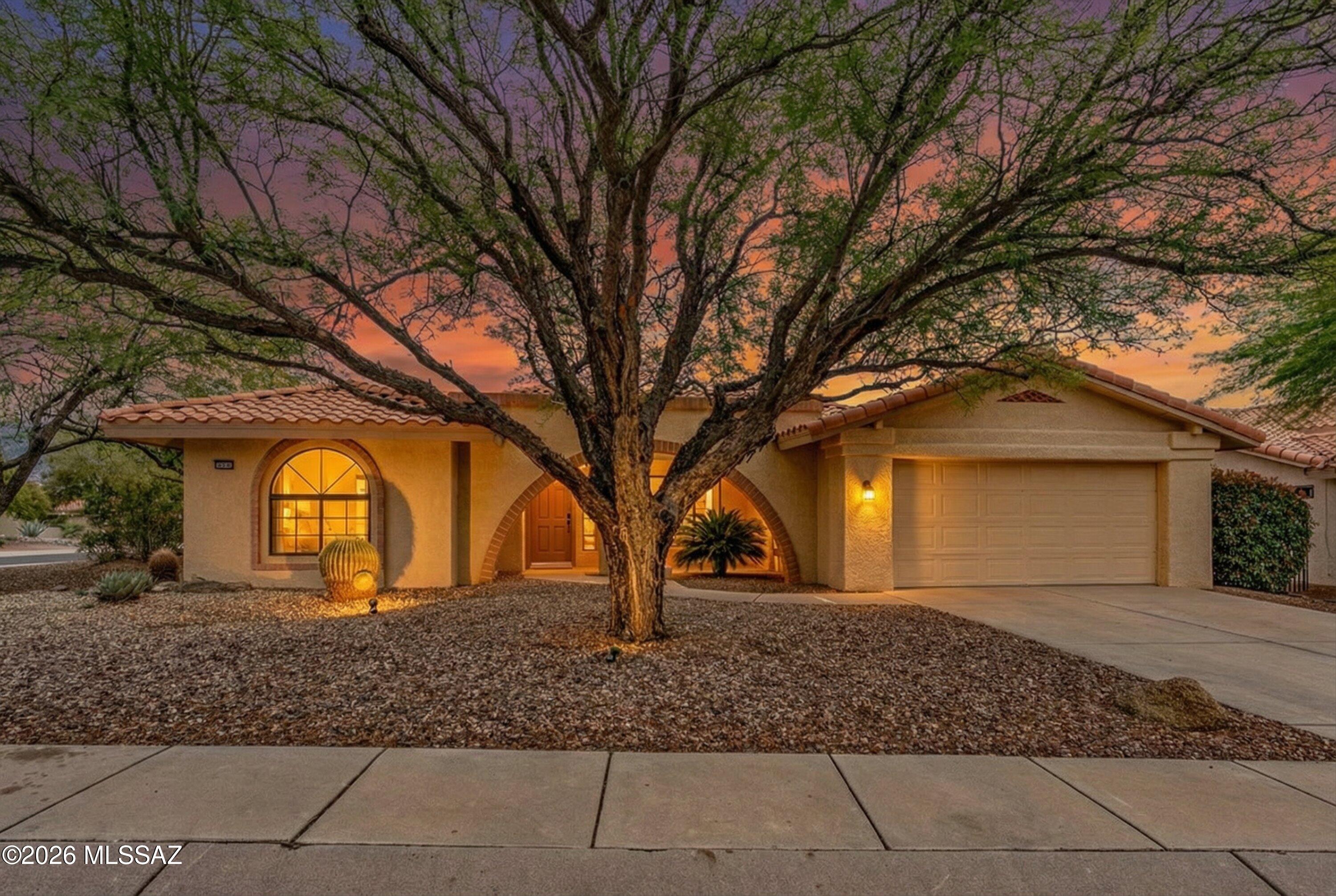 Stunning Silver Creek model in Sun City Oro Valley -- one of the community's most beloved floor plans, and it shows.
This single-level home greets you with a dramatic arched entry framed by a magnificent mature tree canopy, with mountain views and a warm stucco façade that glows at golden hour. Inside, generous living spaces flow effortlessly, featuring both a formal living room and a light-filled family room with patio access, all centered around a well-appointed kitchen.
The kitchen offers abundant cabinetry, stainless steel appliances, a gas range, and generous counter space, all within a functional layout that opens seamlessly to the breakfast nook and family room. The sunlit eat-in nook is surrounded by windows--an ideal spot to enjoy morning coffee while taking in backyard and mountain views. The adjacent family room features built-in cabinetry and shelving, adding both character and everyday functionality.
A thoughtfully designed 2-bedroom, 2-bath layout provides both comfort and functionality, with well-defined spaces for everyday living and guests. The spacious primary suite offers a bay window with mountain and garden views, while the ensuite bath features dual vanities and a walk-in shower--creating a comfortable and functional retreat. A secondary bedroom and full bath provide ideal space for guests.
A dedicated office or flex space with a built-in workspace adds versatility for hobbies, reading, or working from home.
Step outside to a covered rear patio and enjoy the east-facing backyard--perfectly positioned for morning sun and shaded afternoons. A charming patio seating area offers the perfect place to relax and take in the desert landscape and mountain views as the sunset reflects across the peaks.
Additional highlights include newer carpet, desert landscaping front and back, a two-car garage with built-in storage cabinets, and the home is being sold furnished--making this a true move-in ready opportunity.
World-class Sun City amenities -- pools, tennis, fitness, golf and more.
Homes with this floor plan, views, and move-in ready condition don't come up often--schedule your private showing today.
Represented by a boutique luxury brokerage known for taking on only the most exceptional homes in Oro Valley and the greater Tucson area. This one earned it.