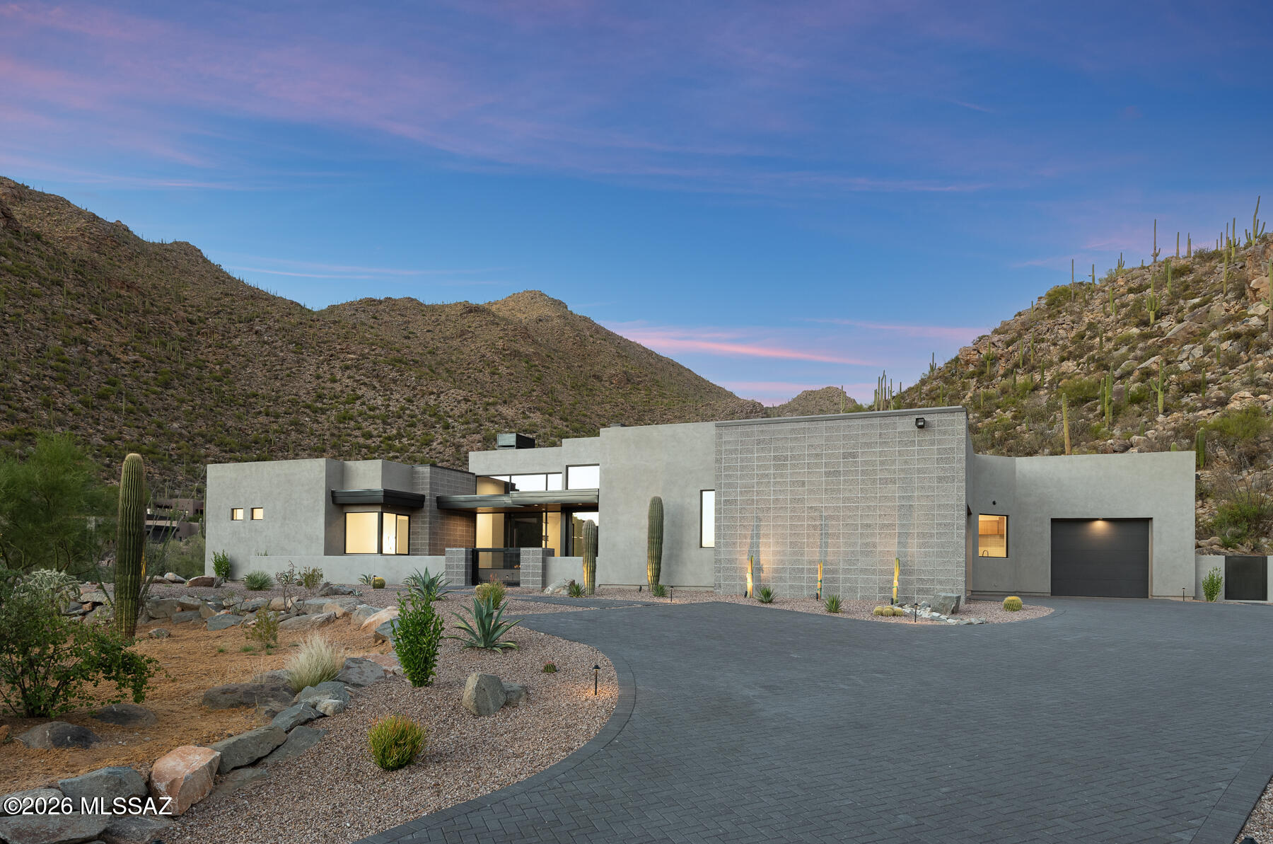 Stunning Custom Modern Home in the Private Gated Community of Canyon Pass at Dove Mountain

Experience elevated desert living in this meticulously designed, single-story custom home, just over a year old and crafted with exceptional attention to detail. Located within the exclusive gated community of Canyon Pass at Dove Mountain, this residence is surrounded by breathtaking mountain landscapes, with stunning views captured from every window.

Inside, you'll find white oak rift-cut custom cabinetry throughout, paired with striking Cambria quartz countertops and full slab quartz walls that create a clean, sophisticated aesthetic. Expansive large-plank tile flooring flows effortlessly from indoor to outdoor spaces, enhancing the home's open and cohesive design. Tongue and groove ceilings extend both inside and out, adding warmth and architectural character.

At the heart of the home is a true gourmet kitchen, featuring premium JennAir appliances and anchored by two impressive 10-foot quartz waterfall islands--perfect for entertaining or everyday living. A sleek Flare fireplace anchors the front living space, adding warmth and modern style.

The custom primary suite offers a spa-like retreat, complete with a heated bathroom floor and a fully built-out closet featuring integrated dressers.

Designed for both relaxation and entertainment, the home includes a dedicated media room with an 11-speaker surround system, laser projector, and acoustic screen.

Step outside through your 10-foot glass sliding doors to a private outdoor oasis featuring a pool with cover, an 18-foot custom linear fire pit, and a fully equipped outdoor kitchen with grill, kamado, and pass-through window--ideal for seamless indoor-outdoor entertaining and enjoying Arizona evenings under the stars.

Additional premium features include:
- Hidden pantry with quartz countertops
- Concealed safe closet
- Electrical outlets discreetly integrated within cabinetry for a clean look
- Flo smart water shutoff system
- Polyaspartic garage floors with built-in cabinetry
- Oversized garage with mini-split system with 2 cross breeze garage doors --perfect for a gym or flex space
- Tiled walls in laundry room and all bathrooms
- Central vac
- 6.5'x9' Pivot Door entry
- Spacious mudroom with custom built ins and quartz top
- Full spray foam installation in walls and roof

This fully integrated smart home includes Control4 automation, Lutron shades, Lutron smart switches, Level locks, 6 Ring cameras plus Ring Doorbell, Pentair pool controls, and a robust WIFI network powered by 5 wireless access points.

Impeccably maintained with no pets, smokers, or children, this home offers a like-new living experience with thoughtful upgrades throughout. This is a rare opportunity to own a truly custom, modern home where luxury meets precision, privacy, and panoramic views.

Turnkey Opportunity: Furnishings are negotiable and can be included under a separate bill of sale-including designer Italian furniture in the front room, primary bedroom, and media room-offering a seamless, luxury move-in experience.
