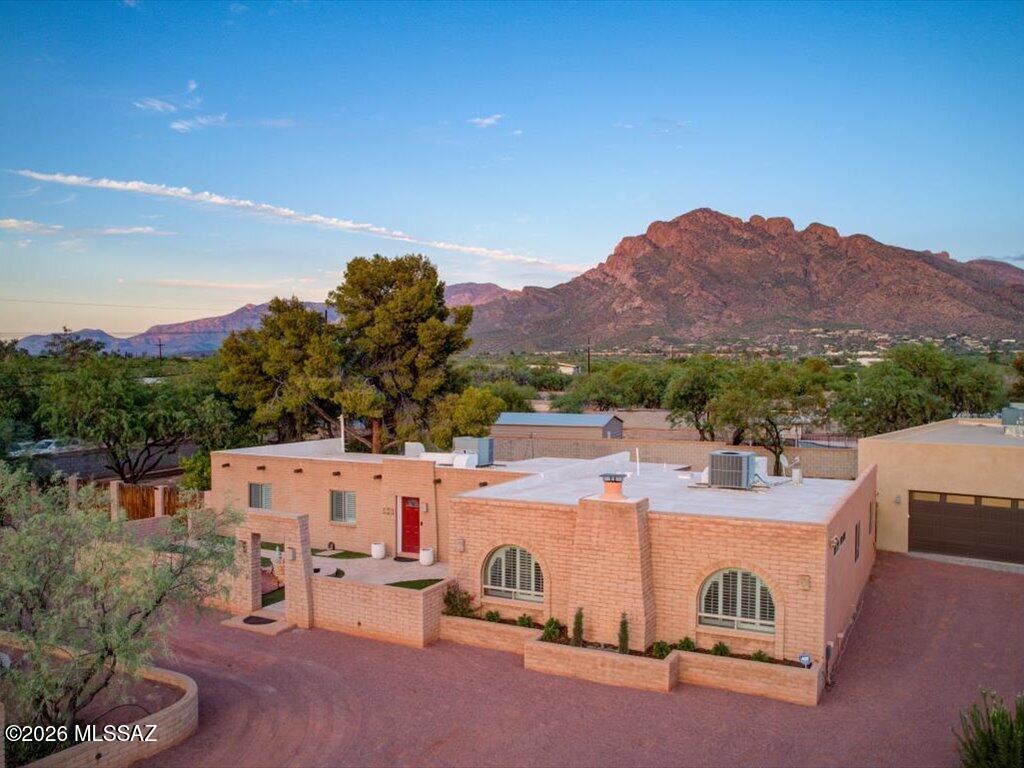 Owner/Agent - Renovated home on .62 of an acre, Pusch Ridge views. Private courtyard w/water feature. Vinyl plank floors, custom knotty alder cabinets. 4BR/3BA + den/office off primary suite w/dual walk-in closets; one BR has ensuite bath. Open family room, wood fireplace, plantation shutters. Covered porch to flagstone patio, outdoor kitchen w/grill, sink and eating bar. Two fire pits, hot tub, gardens, citrus on drip. Dog run, storage w/electric and water, 2-car garage. Detached 2 bedroom, 1 bath guest house  with walk-in closet for multi gen living or guests.