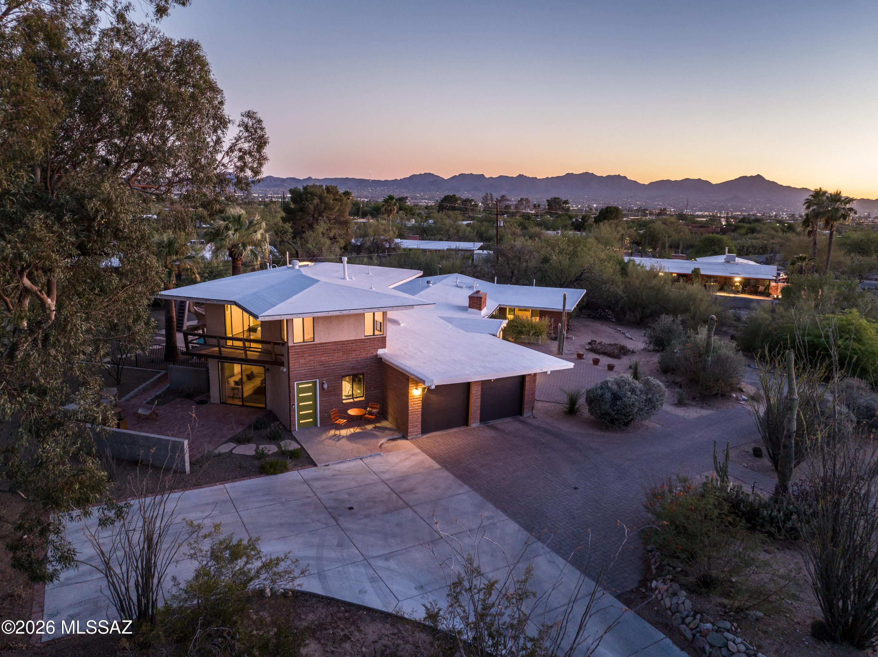 Welcome to this extraordinary and beautifully updated 7 bedroom, 4 bath two story brick estate set on a private .80 acre lot in highly desirable Northwest Tucson with no HOA. This one of a kind property delivers space, flexibility, and true resort style living.

The home includes a fully attached private studio with its own entrance, patio, full kitchen, full bath, washer and dryer, offering an ideal setup for guests, extended family, or income producing potential. Inside the main home, the spacious primary suite is conveniently located downstairs, while two upstairs bedrooms open to private balconies where you can take in sweeping desert views and unforgettable Tucson sunrises and sunsets.