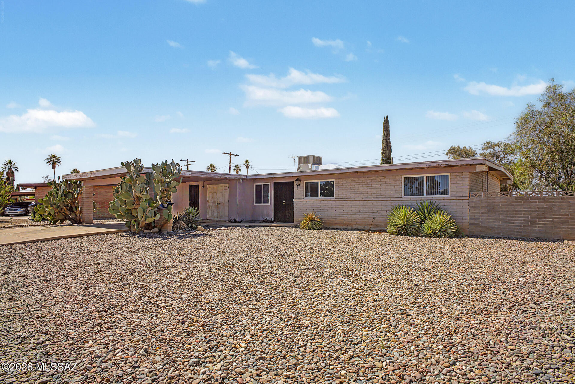 This 3-bedroom residence offers incredible potential for a buyer ready to make it their own. Featuring an attached carport and low-maintenance desert landscaping, the home welcomes you with multiple living spaces, including a spacious living room with floor-to-ceiling windows that fill the home with natural light, a family room off the kitchen, and a dedicated dining area ideal for gatherings.

The kitchen offers ample wood cabinetry, built-in appliances, and a breakfast bar for casual dining. The primary suite includes private backyard access through sliding glass doors and an en-suite bathroom with a walk-in shower. Step outside to enjoy mountain views and a covered patio perfect for relaxing or entertaining outdoors. 

Conveniently located near shopping, restaurants, and bus lines,  property presents a fantastic opportunity for someone with vision to add their personal touch and build equity.
