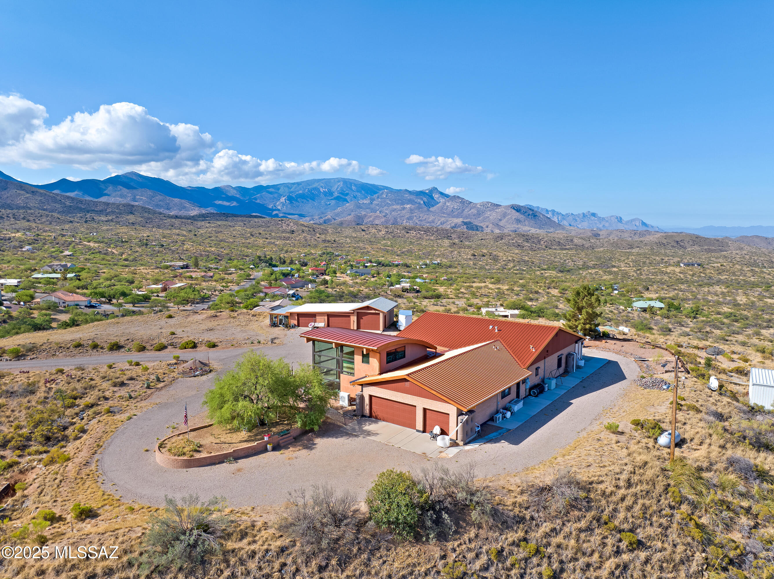 Discover elevated desert living at its finest in this custom 3,596 sq ft estate perched on 5.28 acres at one of Oracle's highest vantage points. Surrounded by extraordinary 360° mountain views and of multiple ranges, with a commanding perch that overlooks the entire town of Oracle.  This meticulously upgraded residence delivers rare privacy, refined finishes, and a layout designed for comfort, security, and versatility. 
The home features 4 bedrooms, 3 baths, and a flexible bonus space which could ideal for an office, fitness area, media space, or creative studio. the impressive 896 sq ft guest addition expands the living experience with floor-to-ceiling glass that frames sweeping natural scenery--perfect for visitors and multi-generational living at its best! The interior has been fully renovated with high-quality materials, updated cabinetry, upgraded counters, and modern flooring. Expansive windows bring in abundant daylight while capturing panoramic views from nearly every angle. A bright sunroom enhances the home year-round, naturally warming the living areas during cooler months and offering a comfortable space to enjoy the changing seasons.

Designed with security and longevity in mind, the property includes rolling window shutters, reinforced exterior doors, a standing seam metal roof, and a leaf-filter gutter system. These features create a worry-free lock-and-leave environment with exceptional durability.

Outside, a chip-seal driveway leads to your 8 garages one attached and two detached plus an attached greenhouse. The land offers mature fruit trees, wide-open space suitable for horses, and room for additional amenities, including an area usable as a helipad. A rainwater harvesting system with multiple collection barrels contributes to sustainable living and reduces reliance on municipal water.

This horse property combines elevated luxury, practical upgrades, and a setting that must be seen to be believed. From sunrise to sunset, every moment here is framed by unmatched scenery and peaceful desert beauty. A rare opportunity to own one of Oracle's most remarkable properties. See feature sheet