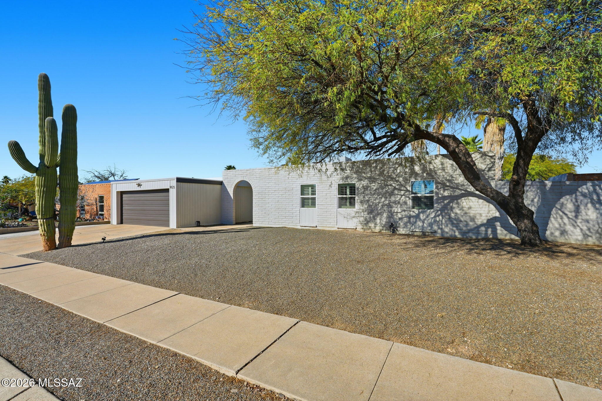 A beautifully updated home with stunning backyard mountain views awaits you. Step through a custom security door into an inviting open floorplan accented by rich laminate wood flooring. Enjoy a cozy wood-burning fireplace, newer lighting and fans, as well as tastefully updated bathrooms. The expansive Owner's Suite features French doors leading directly to the tranquil backyard. Major systems have been thoughtfully replaced--including the HVAC, roof, and water heater--offering peace of mind for years to come. Outside, refreshed desert landscaping surrounds artificial grass, palm trees, and stately saguaros. Relax or entertain by the PebbleTec saltwater pool and spa, upgraded with a newer autofill, heater, and filtration system. This home blends comfort, updates, and outdoor beauty.