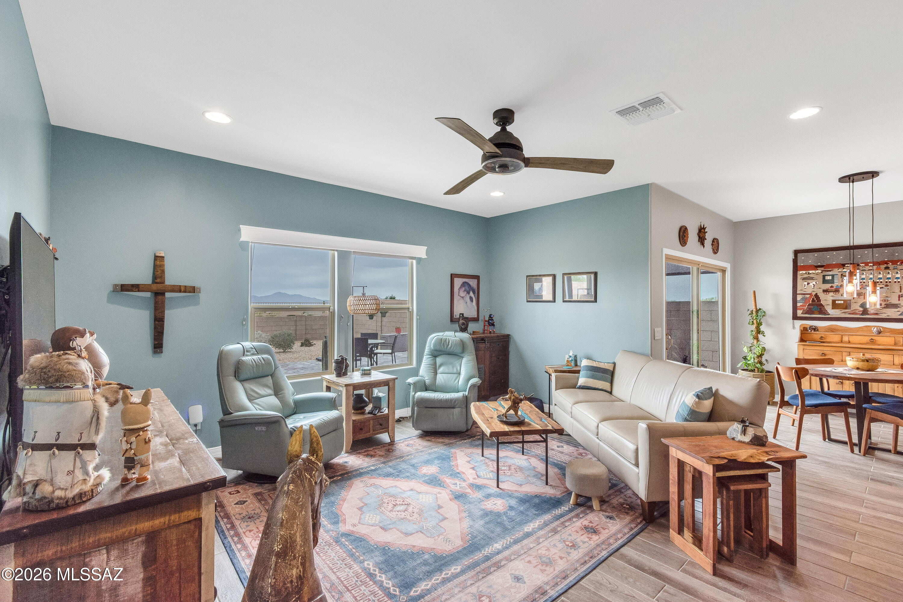 This home features MOUNTAIN VIEWS AND GORGEOUS BACKYARD ON A PREMIUM LOT.  The is a beautifully maintained, two-year-new home and is truly move-in ready.  Unlike many new builds, the finishing touches are already in place--saving you time, effort, & added expense. Enjoy upgraded wood-look ceramic tile throughout (no carpet), custom ceiling fans, & stylish window treatments. Thoughtful upgrades continue in the kitchen & baths, incl a water softener & reverse osmosis system at kitchen sink. The primary suite has been enhanced w/expanded counter space, a versatile armoire replacing open shelving, & a redesigned closet offering improved storage for clothing & shoes. Step outside to a backyard designed w/ desert-friendly landscaping & easy maintenance in mind. Front patio features a charming fenced area--perfect for relaxing w/your morning coffee The community offers shared outdoor spaces including a playground & grassy area, with convenient access to nearby schools, (less than .5 mile to Marana K-8 Stem School as the crow flies!) , shopping, restaurants & so much more.