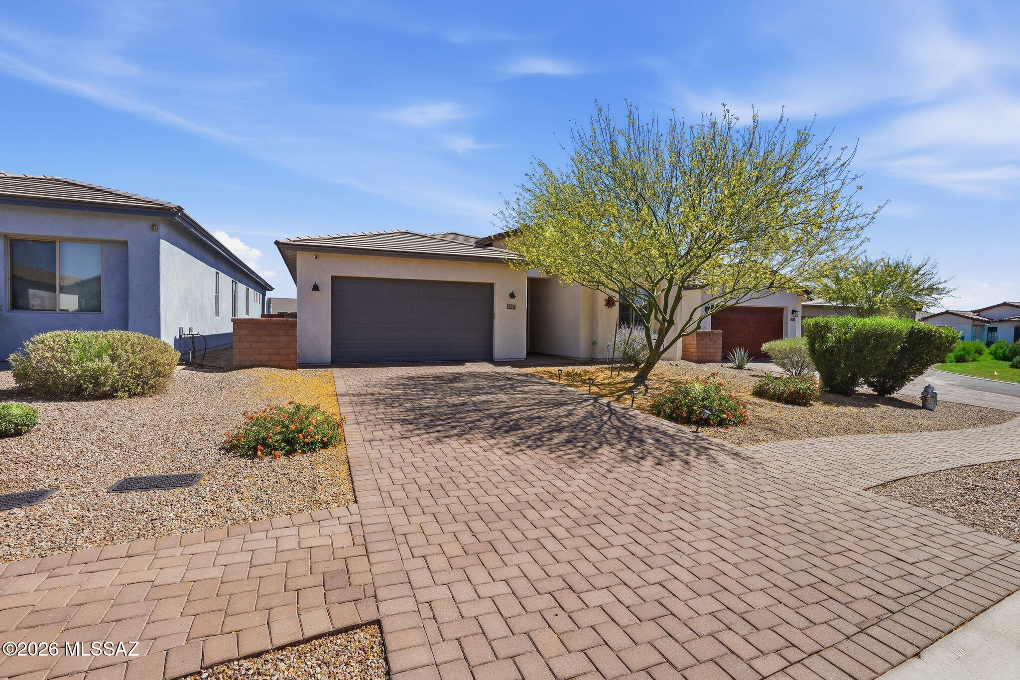 Located in a gated community in desirable Northwest Tucson, this beautifully upgraded 3 bedroom, 2 bathroom home offers 2,005 sq ft of modern comfort, quality finishes, and low-maintenance living. The open-concept floorplan features upgraded tile flooring throughout, white painted soft-close cabinetry with upgraded plywood interiors, and stunning Fantasy White Satin marble countertops in the kitchen. Gourmet kitchen highlights include a gas cooktop, wall ovens, KitchenAid refrigerator, built-in wine fridge, filtered WaterTec drinking water system, and under-cabinet ambient lighting perfect for entertaining.

The spacious primary suite features an upgraded oversized soaking tub, upgraded comfort-height toilet, and a clean, modern feel throughout. Additional upgrades include premium wood shutters on every window, WiFi thermostat, soft water loop, and designer touches throughout the home. Step outside to a beautifully landscaped low-maintenance backyard with turf and a motorized patio shade system that fully encloses the patio, creating the perfect Arizona outdoor living space year-round.

Enjoy peaceful gated living with convenient access to shopping, dining, golf, and outdoor recreation including nearby Trader Joe's, Tucson National Golf Club, and Linda Vista Trail.