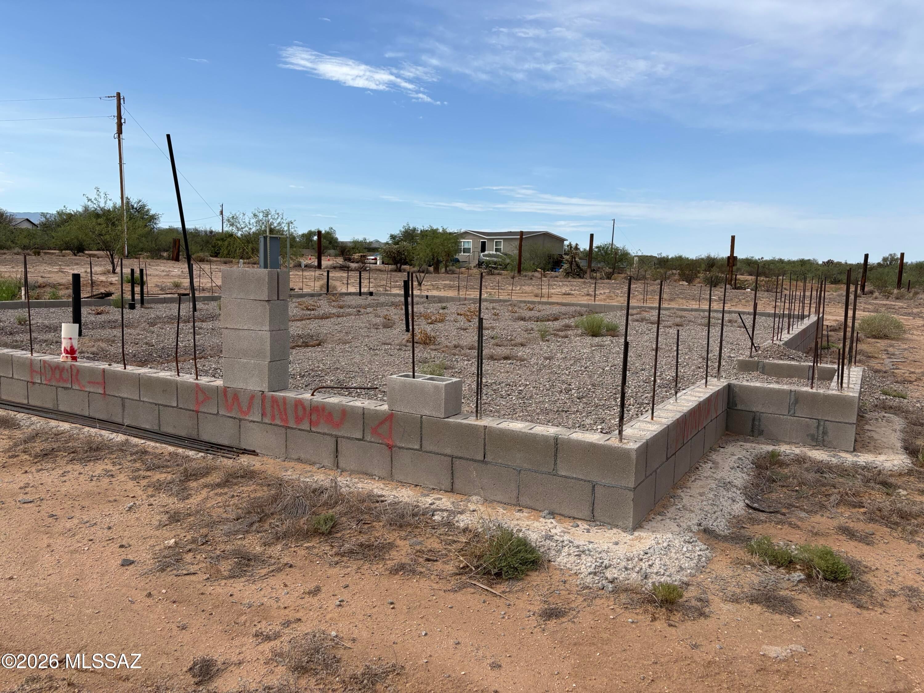 Single family 1750 sq ft block house is already started - see plans - foundation, electric, septic, water and permits are in place - fees paid - ready to complete.  2++ acre corner lot - one mile of good dirt road to pavement.  Great family location - finish it up for your dream home or flip.