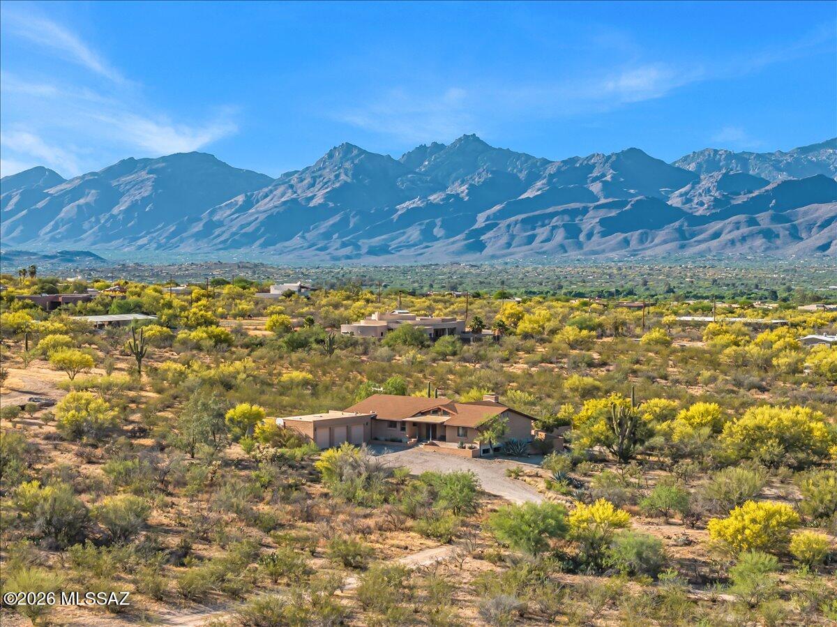Tucked away on 4.56 private acres with gorgeous mountain views, this solid 1986 slump block/brick home delivers east side acreage living at its finest. Soaring high ceilings, a fully updated kitchen, renovated spa like main bathroom, and a beautiful renovated pool with covered patio create the perfect indoor-outdoor lifestyle. A wood-burning fireplace anchors cool desert evenings while the finished basement adds rare versatility -- office, gym, or guest space. 3-car garage, small horse corral, SR zoning, & no HOA add to the appeal. Located in the highly sought-after TV School District with quick access to east side shopping, dining, and the trailheads of Saguaro National Park East, this is the rare property that checks every box without asking you to compromise on a single thing!