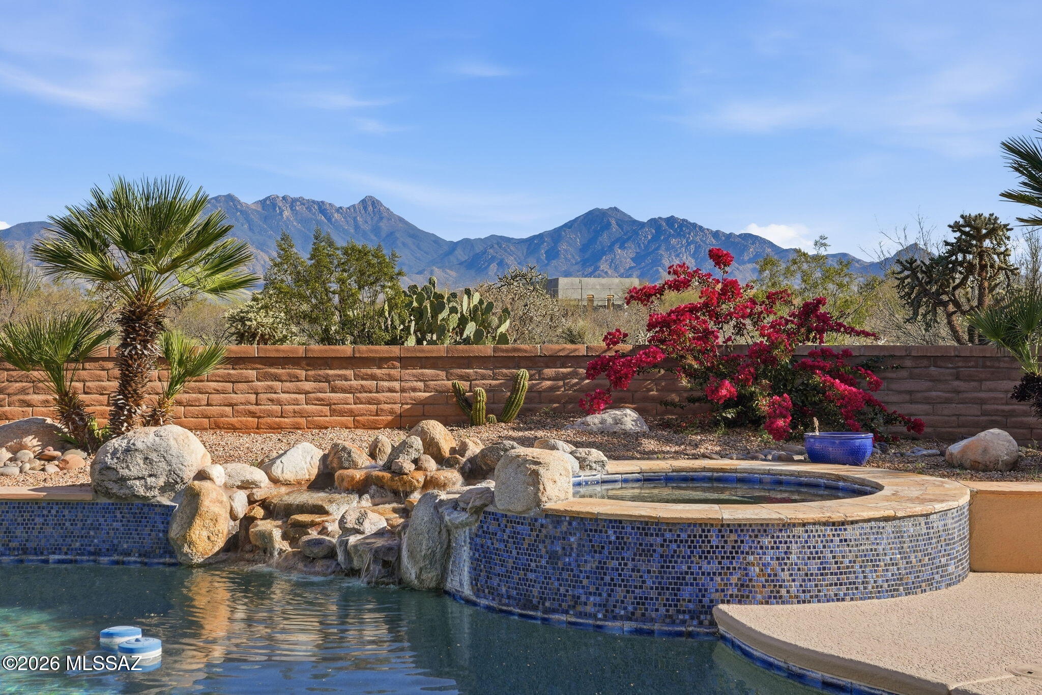 Framed by the breathtaking Santa Rita Mountains, this exceptional custom Dorn-built home in Pasadera sits on 4.14 private acres, offering sweeping desert views & refined Arizona living. A charming enclosed front courtyard with a decorative fountain welcomes you, setting the tone for the tranquility found throughout the property. The backyard is designed as a private desert retreat with a gas-heated pool & spa featuring a double waterfall, expansive Kool decking, a built-in BBQ, & a gas fire pit--perfect for entertaining while enjoying spectacular mountain sunsets.  Inside, the home blends comfort & elegance. The gourmet kitchen features granite countertops, abundant custom cabinetry, double ovens, trash compactor, & under cabinet lighting. The adjoining family/game room is an entertainer's dream with a billiards area, media center, and wet bar with wine fridge and mini fridge. A formal dining room with an illuminated tray ceiling adds a touch of sophistication for special gatherings. The split bedroom floor plan offers privacy, with the spacious primary suite capturing mountain views and featuring built-in cabinetry, dual vanities, a jetted soaking tub, custom tiled walk-in shower, and a large walk-in closet with custom organization. A dedicated office/den provides the perfect work-from-home space.

Additional highlights include an expansive laundry room that doubles as a hobby room, a three-bay oversized garage with workshop and storage, and a soft-water hose bib for washing vehicles.

Important upgrades include owned solar for low utility costs, HVAC replaced in 2016 (warranty through Sept 2026), dual-flush toilets, new service utility doors, and fresh exterior paint with updated landscape rock and drip irrigation.

Surrounded by mature desert landscaping and towering saguaros, this remarkable property offers privacy, space, and unforgettable views. GVR membership is not included but can be added if desired.