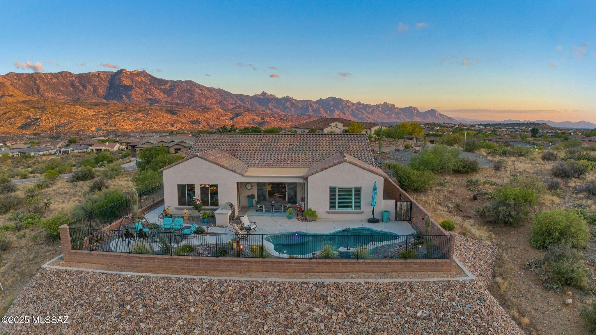 Beautiful Mountain views + saltwater pool set the tone for this 3BD+Den+Office contemporary home on a private 1.26 acres in gated Sundance Ridge near SaddleBrooke. $265K+ in post-purchase upgrades incl. OWNED solar. Ideal for gourmet chefs & wine/coffee aficionados w/granite, entertainer's island, gas cooktop, huge walk-in pantry + built-in Miele coffee station. Custom wine lounge includes Thermador wine cooler + 2-drawer beverage fridge & built-in cabinetry w/glass-faced uppers. Owner's suite has LVP flooring, custom closet + extended tiled walk-in shower. Guest wing includes 2BD, full bath, den + office. Owner's entry wing adds powder room, extended laundry, drop zone + split 3-car garage. Built-in BBQ, patios + SaddleBrooke HOA 2 golf/dining access (non-res rates). No age restrictions!