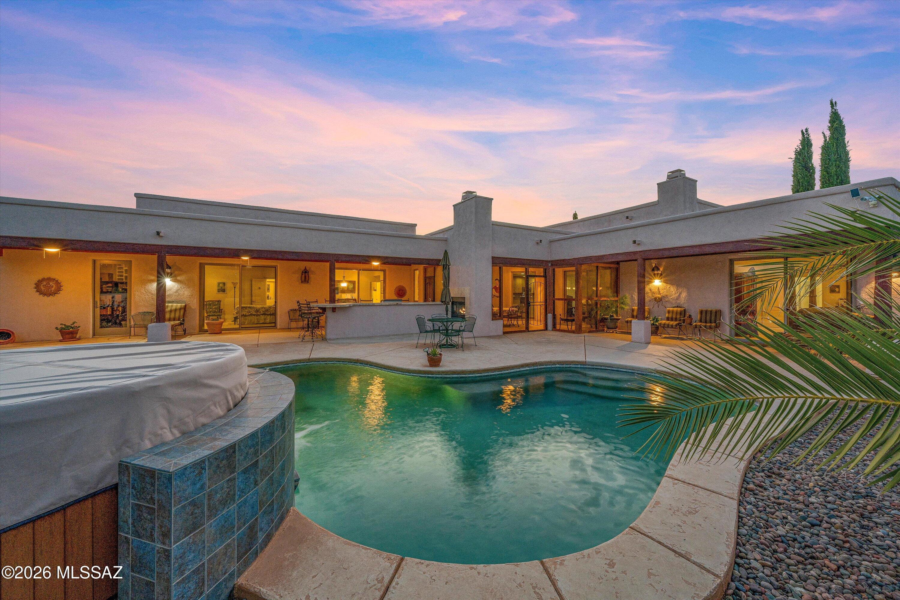 AN EXTRAORDINARY VALUE. ONE ACRE. NO HOA. Catalina Mountain Views. 5-Car Garage + RV Space. Resort-Style Backyard.  This isn't simply a large home, it's a private, custom built Southwest estate designed for entertaining, multigenerational living, animals and hobbies. Split floor plan, 5 bedrooms, 5 baths, bonus room, three en-suite bedrooms (two separate wings), theater, recreation room, exercise room, office, custom alder kitchen, wet bar and an incredible indoor/outdoor living setup, this property offers something exceptionally difficult to find. Step outside: saltwater pool, waterfall, outdoor kitchen, built-in grill, screened porch, courtyard fountain, fruit trees, Mexican Talavera Tile, and vegetable garden. Oversized solar system paid at COA and new hot tub. This property is a MUST!