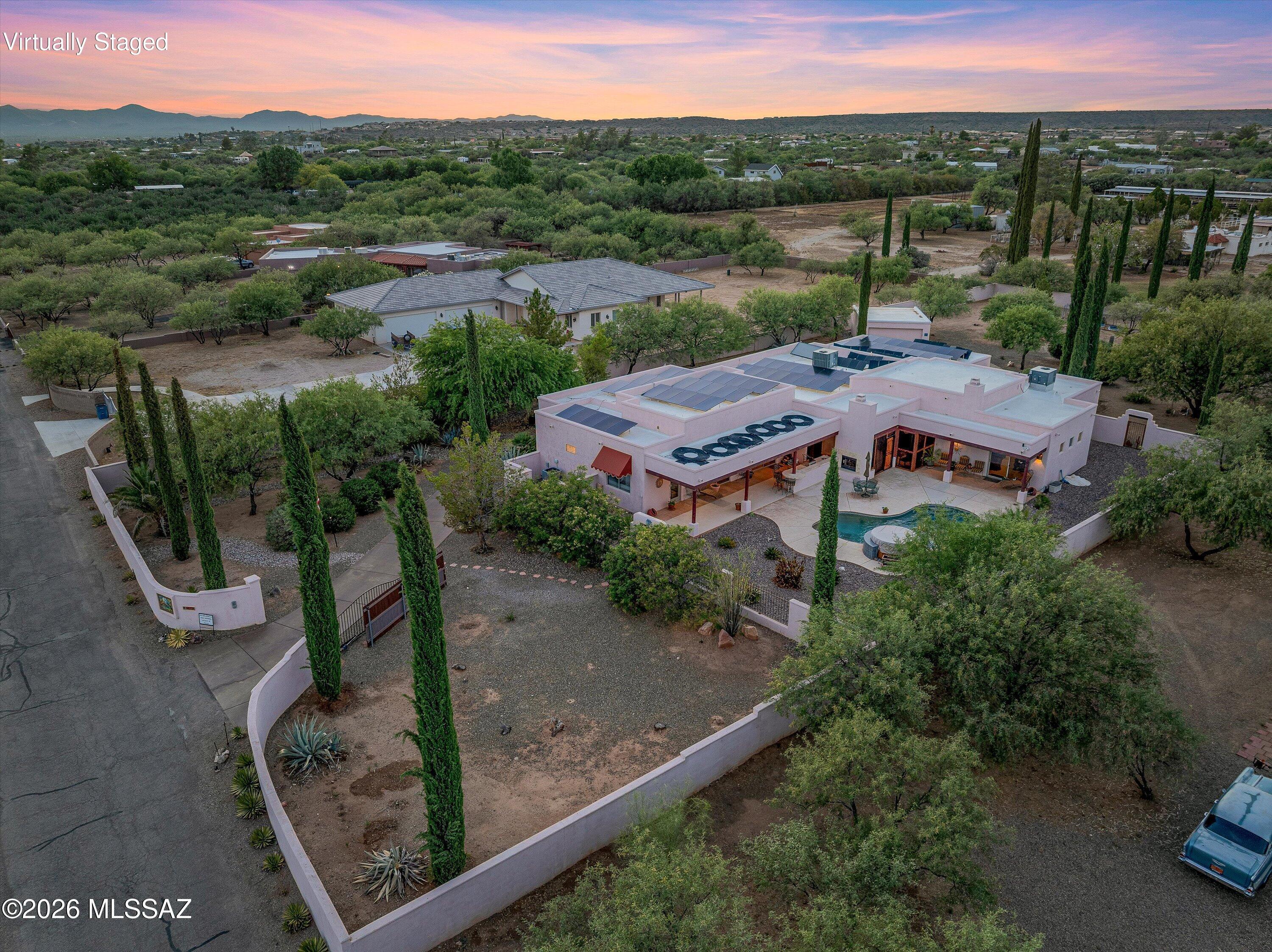 AN EXTRAORDINARY VALUE. ONE ACRE. NO HOA. Catalina Mountain Views. 5-Car Garage + RV Space. Resort-Style Backyard.  This isn't simply a large home, it's a private, custom built Southwest estate designed for entertaining, multigenerational living, animals and hobbies. Split floor plan, 5 bedrooms, 5 baths, bonus room, three en-suite bedrooms (two separate wings), theater, recreation room, exercise room, office, custom alder kitchen, wet bar and an incredible indoor/outdoor living setup, this property offers something exceptionally difficult to find. Step outside: saltwater pool, waterfall, outdoor kitchen, built-in grill, screened porch, courtyard fountain, fruit trees, Mexican Talavera Tile, and vegetable garden. Oversized solar system paid at COA and new hot tub. This property is a MUST!