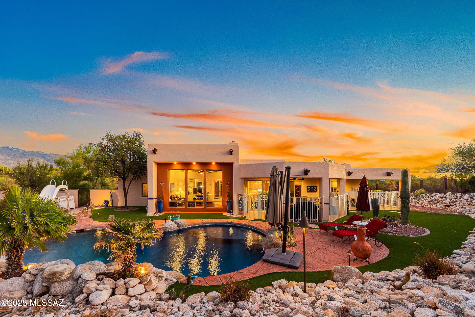 Tucked behind a secure gated entrance, this stunning 3.86-acre estate offers a private,
resort-style retreat unlike any other. As you travel up the long private driveway and pass
through a double-gated courtyard, you're welcomed into a tranquil oasis featuring a koi
pond with a waterfall, lush landscaping, and a serene, peaceful ambiance. This custom-designed residence is a true architectural masterpiece, blending luxurious finishes with timeless design elements. Inside, you'll find exquisite custom red mesquite wood flooring imported from Mexico gracing the living room, den, and master suite, complemented by porcelain tile. Solid alderwood doors and cabinetry lend warmth and sophistication, while wood-beamed ceilings in key living spaces create a refined yet inviting atmosphere.
The gourmet kitchen is a chef's dream, showcasing granite countertops, appliances and an open-concept layout that flows effortlessly into a cozy breakfast room and spacious great room highlighted by a see-through gas fireplace.
The expansive master suite provides a peaceful retreat, complete with its own sitting area, dual-sided fireplace, and a spa-style bathroom. Floor-to-ceiling windows throughout the home flood the interiors with natural light and frame in the breathtaking views of the surrounding grounds.
Step outside to your covered patio oasis, ideal for entertaining or quiet relaxation. Enjoy a sparkling saltwater pool with a waterfall feature, surrounded by meticulously designed landscaping which includes turf and ambient lighting that brings the outdoor space to life after dark.
Offering the perfect blend of luxury, comfort, and seclusion, this one-of-a-kind estate is a must-see!