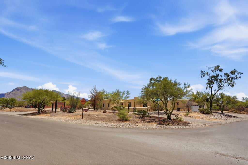 Nestled on a serene corner lot in Ranchos De La Canada, this stunning Santa Fe-style residence embodies the warmth and beauty of desert living. Start your mornings with coffee on the covered patio as the Catalina Mountains glow in the sunrise, and end your evenings beneath a canopy of stars beside the heated pool and spa.

The lush desert landscaping, mature trees, and private courtyard create a peaceful retreat perfect for entertaining or relaxing. Inside, handcrafted Mexican tile floors, a cozy beehive fireplace, and sunlit spaces infuse the home with authentic Southwestern charm. With four spacious bedrooms, refined finishes, and timeless architectural details, this home offers the privacy, mountain views, and effortless elegance that make Tucson living truly extraordinary.