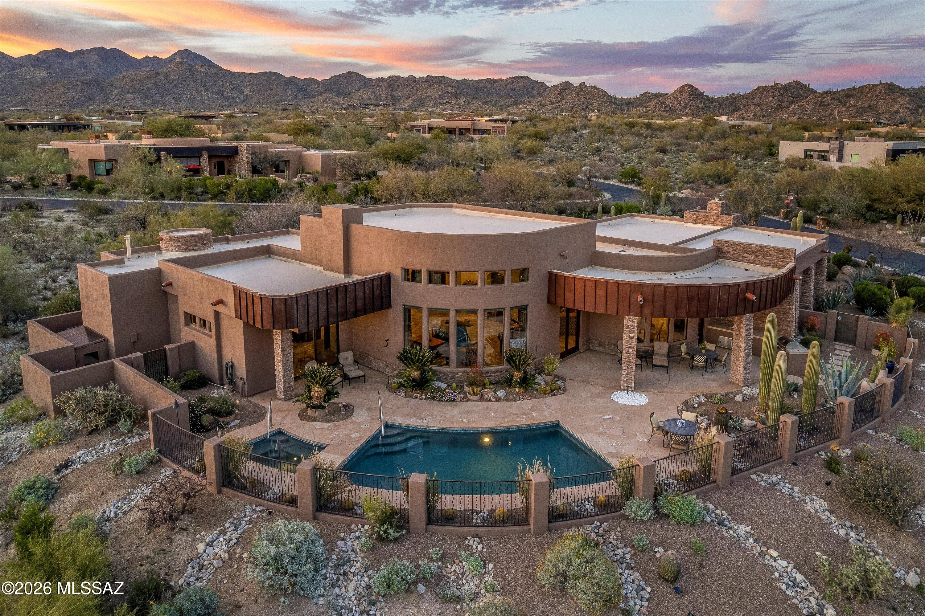 Nestled in guard-gated Stone Canyon, famed for its exclusive scenic desert golf course, this residence captivates from the very moment you step through the door. Soaring ceilings and expansive glass walls frame the majestic Catalina Mountain views. The elegant split layout features timeless travertine and wood flooring, wine bar and stacked stone fireplace. The grand primary suite offers a private retreat with a patio and stunning views. A chef's dream, the kitchen boasts a large island, professional SS appliances, 48'' gas cooktop, expansive breakfast bar and walk-in pantry. Backing to natural desert, the backyard is an entertainer's oasis with grand covered patio, built-in BBQ, sparkling pool & spa. Just minutes from the clubhouse & fitness center, this is the pinnacle of luxury living.