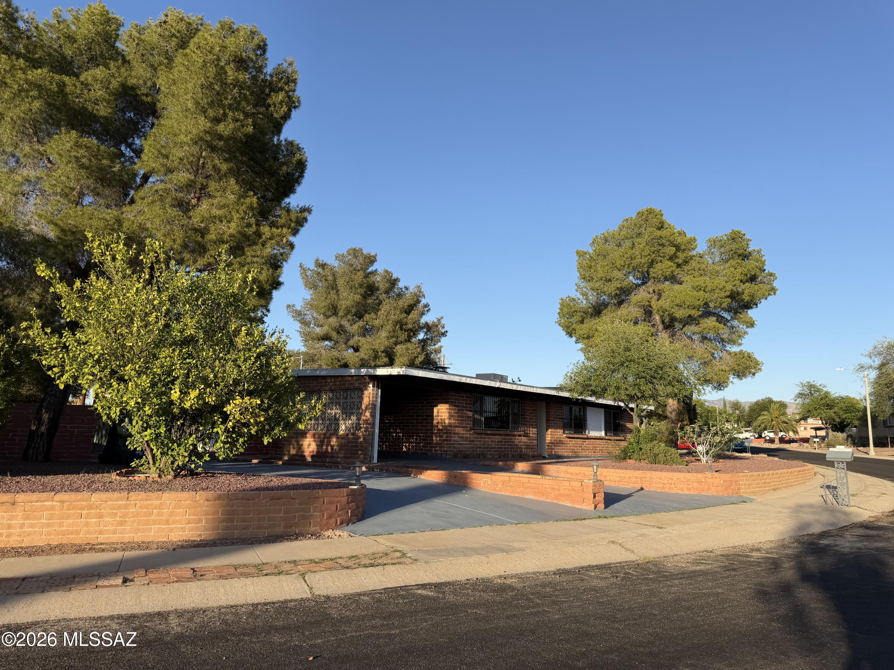 Spacious home on a large lot with beautifully maintained, easy-care front and backyard landscaping. The backyard features a partially in-ground above-ground pool with surrounding deck, covered patio with ceiling fan, fenced garden area ready for flowers or vegetables, citrus trees, mature pine tree providing afternoon shade, and two large storage sheds offering excellent storage or workspace options. Wide gate allows vehicle access to the backyard. Inside, the kitchen includes a large island, stainless Frigidaire range and refrigerator, Maytag dishwasher, and abundant space for entertaining. Skylights brighten the dining area and both bathrooms. Newer carpet, ceramic tile, ceiling fans, dual cooling, fireplace, and large utility room add comfort and flexibility throughout the home