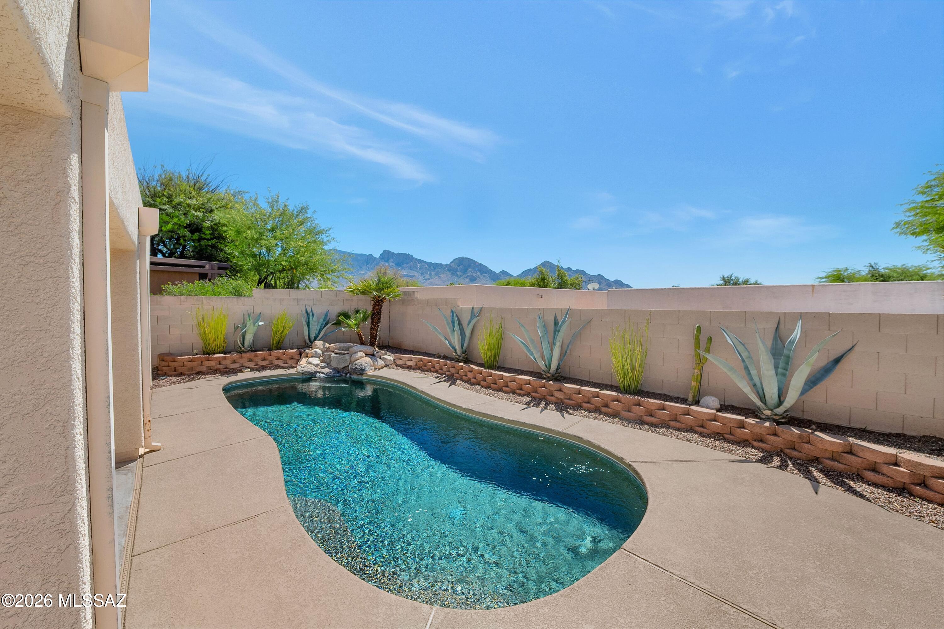 .Well-maintained corner lot home with mountain views and a pool in the desirable Rancho Vistoso community. Interior features include vaulted ceilings and a light, inviting palette. The kitchen has been  updated with new countertops and new appliances, offering both style and functionality. The split floor plan provides comfortable living, with a spacious primary suite featuring a double-door entry, a private en suite with dual sinks, and generous closet space. Recent improvements include roof repairs, interior painting, and refreshed pool decking, enhancing the home's overall value and condition. Step outside to enjoy a sparkling pool, covered patio, and low-maintenance desert landscaping, perfect for relaxing or entertaining. Ideally located near shopping, dining, and everyday conveniences.