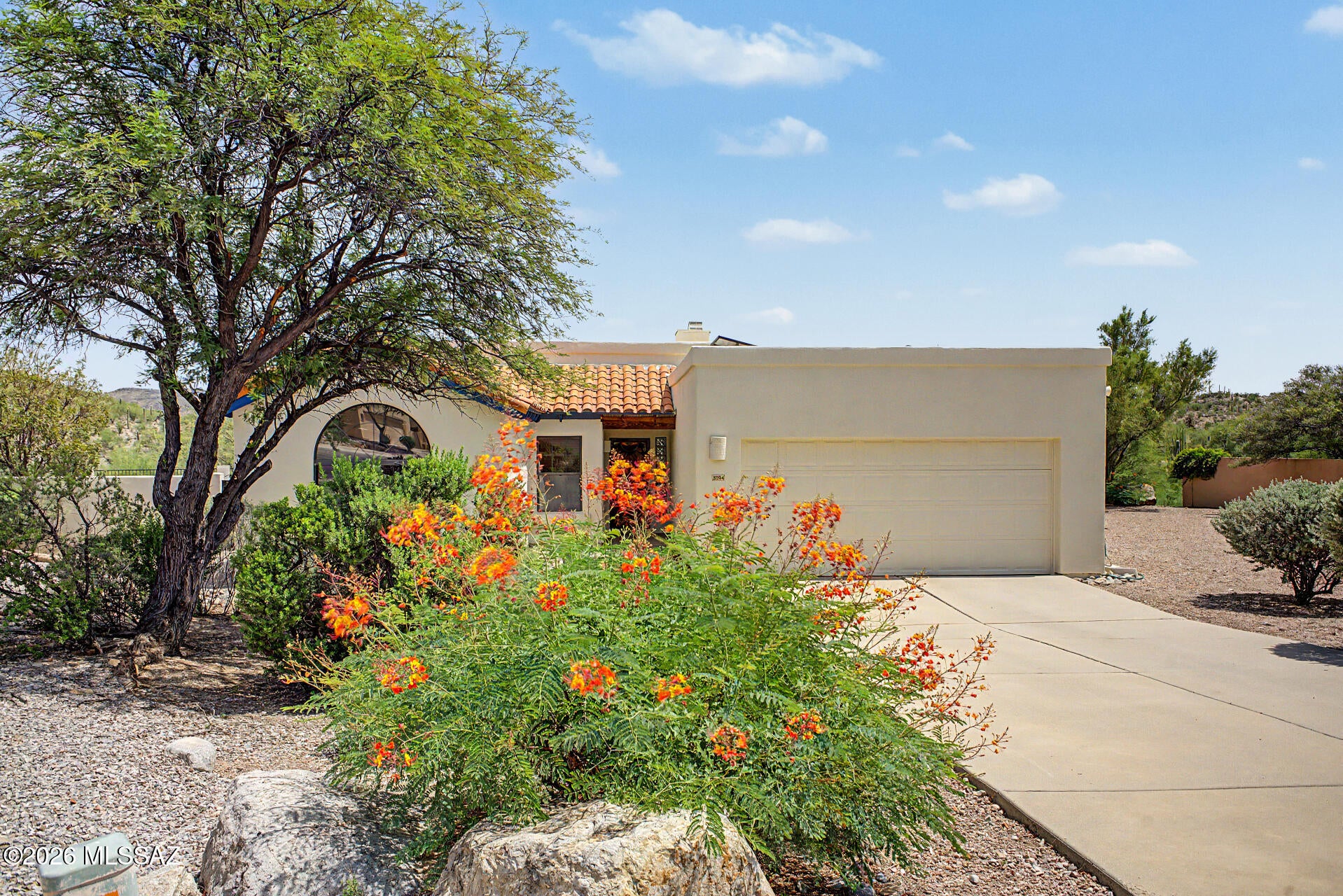 STUNNING MOUNTAIN VIEWS! This lovely 3-bedroom, 2-bath golf course home is move-in ready and features expansive views of the fairways and distant mountain vistas. It's located on an oversized premium lot with extra privacy due to an empty easement next door. All of this in the sought-after Starr Pass neighborhood. A major BONUS is the Fully Owned Solar array that keeps monthly electric bills very low. This home showcases a living room with high ceilings, a soothing palette, custom tile flooring throughout, and a cozy beehive fireplace for relaxing evenings with loved ones. The eat-in kitchen has plentiful light with multiple windows and sliding doors that bring the outside in. The kitchen is equipped with quartz counters, ample wood cabinetry, a designer tile backsplash, sleek stainless steel appliances, a separate wine refrigerator below the coffee bar and a peninsula with a breakfast bar for casual dining. The primary bedroom features convenient backyard access, a large walk-in closet, a private bathroom with double sinks, a separate toilet room, walk-in shower and soaking tub. Two additional rooms are ample size and share the nicely appointed hall bathroom. Imagine yourself enjoying peaceful afternoons in the charming backyard, which offers a covered patio, abundant space for outdoor relaxation, and breathtaking mountain views that provide a picturesque backdrop. Additional features include a 2-car garage with built-in storage and an extended driveway for extra parking. Laundry includes an extra bonus: the washer and dryer will convey with the sale. What more could you ask for!