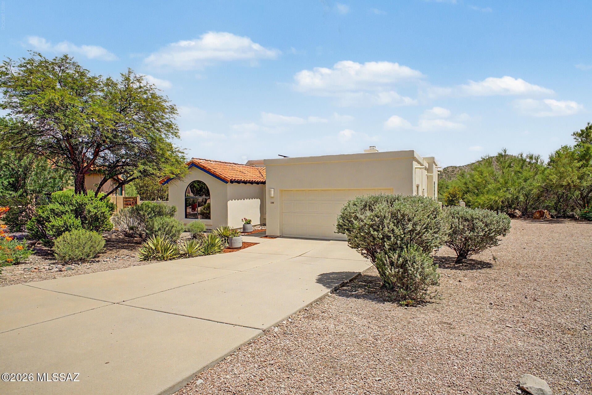 STUNNING MOUNTAIN VIEWS! This lovely 3-bedroom, 2-bath golf course home is move-in ready and features expansive views of the fairways and distant mountain vistas. It's located on an oversized premium lot with extra privacy due to an empty easement next door. All of this in the sought-after Starr Pass neighborhood. A major BONUS is the Fully Owned Solar array that keeps monthly electric bills very low. This home showcases a living room with high ceilings, a soothing palette, custom tile flooring throughout, and a cozy beehive fireplace for relaxing evenings with loved ones. The eat-in kitchen has plentiful light with multiple windows and sliding doors that bring the outside in. The kitchen is equipped with quartz counters, ample wood cabinetry, a designer tile backsplash, sleek stainless steel appliances, a separate wine refrigerator below the coffee bar and a peninsula with a breakfast bar for casual dining. The primary bedroom features convenient backyard access, a large walk-in closet, a private bathroom with double sinks, a separate toilet room, walk-in shower and soaking tub. Two additional rooms are ample size and share the nicely appointed hall bathroom. Imagine yourself enjoying peaceful afternoons in the charming backyard, which offers a covered patio, abundant space for outdoor relaxation, and breathtaking mountain views that provide a picturesque backdrop. Additional features include a 2-car garage with built-in storage and an extended driveway for extra parking. Laundry includes an extra bonus: the washer and dryer will convey with the sale. What more could you ask for!