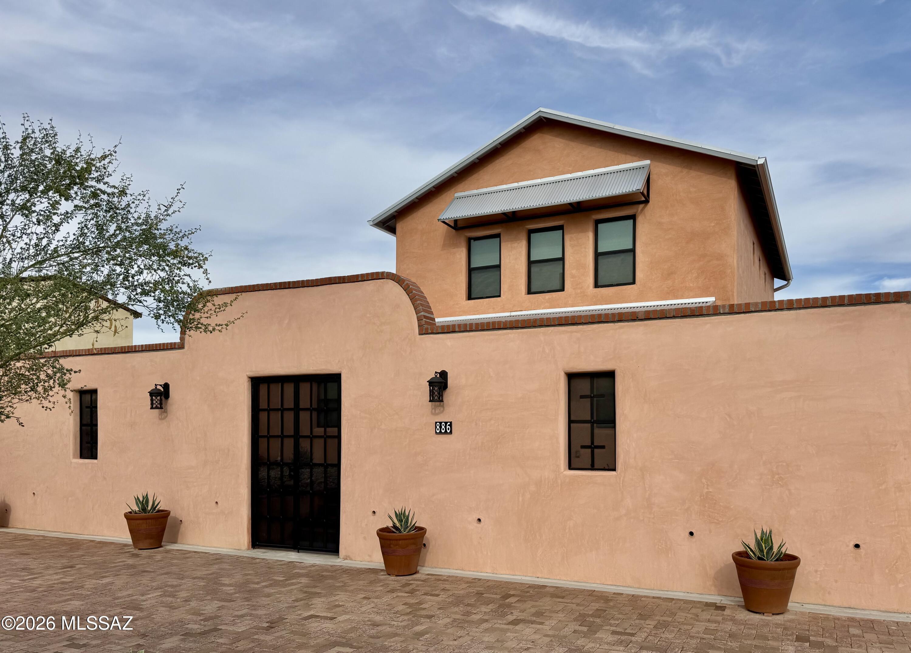Situated within the iconic Mercado District of Menlo Park, this 2025-built custom home embodies the soul of one of Southern Arizona's most treasured communities. Quality ICF construction with luxurious masonry stucco finishing, affording year-round efficiency & tranquility. No expenses were spared here with close attention to detail that emphasizes pride of ownership. Three bedrooms & three bathrooms in 2,323 sq.ft. with quality finishes throughout, including polished concrete floors, 9-foot ceilings, mesquite cabinetry, granite countertops & top-of-the-line stainless steel appliances, including an over-sized range hood over the induction range. Having been built on one of the largest lots in the Mercado District means this home offers true yard space in front, on the side & out back. The two-car garage with extended-height insulated door, a mini-split, built-in cabinetry, prep sink & finished flooring means the home projects can be done in the comfort of a climate-controlled environment. Other highlights include wooden doors, white oak flooring in the stairwell & upstairs, luxurious bathrooms, combination flat & pitched metal roofing, windows galore for natural light, attic storage, mini-split HVAC systems with proper ventilation & filtration, interior sprinklers for fire safety, whole-home water filtration & more! The Mercado District is nestled on land with a rich history as far back as 4,200 years. The thriving Mercado San Agustin & MSA Annex offer dining, shops, access to 'A' Mountain & more! Annual events include the Circus & the All Souls Procession - something you don't want to miss! Via the Street Car, you have easy access to Downtown Tucson & The University of Arizona. Truly a special community, waiting for you!