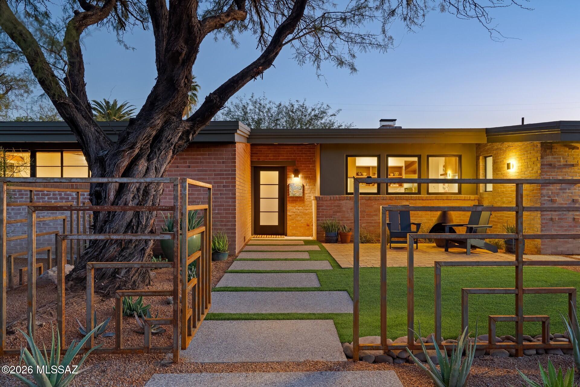 With sensitive selections and simple profiles, this 1948 ranch home is Just minutes to the University of Arizona, the finest restaurants in central Tucson, parks, and the Loop.

This exceptional residence has undergone an extensive renovation where no detail was overlooked—honoring the original architecture while elevating every system, surface, and space.

A rare opportunity to own a historically relevant Catalina Vista home that has been thoughtfully and comprehensively restored, blending midcentury details with modern luxury and sustainability. With walls of glass, exposed brick, and brass lighting fixtures that evoke an era when style reigned supreme, this residence offers the best of Tucson's rich historic architecture.

Neutral, earthy tones, a clear focus on function, and the effortless flow of a reimagined floor plan make this property irresistible. The home features a stunning new primary suite addition, complete with a spa-like bath offering dual sinks, a walk-in shower, glass enclosure,

and refined finishes. The addition is veneered in vintage brick to perfectly complement the original façade.

Concrete floors flow throughout the homeoriginal slabs carefully resurfaced and resealed, with new overlays added where appropriate. Historic windows were meticulously repaired with new glazing and paint, while new Milgard windows and sliding glass doors were added to enhance efficiency without sacrificing character.

The kitchen has been artfully optimized, featuring custom locally crafted cabinetry in clear alder with walnut stain, a custom metal island, quartz countertops, marble mosaic backsplash, a reclaimed wood hood, and all new stainless steel appliances. The gas range also has a dedicated electrical circuit for induction or electric cooking.

Every major system has been upgraded:

" All new electricalpanels, subpanels, and every wire

" New sewer lines to all fixtures in the main house

" Two new HVAC systems with all new ductwork

" New water heater, supply lines, hose bibs, and a whole-house recirculating pump

" Owned solar system for long-term sustainability

Bathrooms have been fully reimagined with new tubs, tile, Heath Ceramics accents, marble and quartz surfaces, new mirrors, fixtures, toilets, valves, and skylights that flood spaces with natural light.

Outdoor living is equally refined. Enjoy a fully renovated pool with new equipment, auto-fill, tile, pebble finish, bench seating, and variable-speed pump. The grounds feature new desert plantings, decomposed granite, turf, custom aggregate walkways, brick patios, metal gates, trellises, privacy walls, and a custom courtyard fence. An exterior bar with granite counters and gray drain sink makes entertaining effortless.

Additional highlights include a guest house with matching custom cabinetry and a three quarter bath. Rigid foam insulation, spray foam insulation, new stucco over insulated framing, custom metal gates and screens, smart security system, EV charging pre-wire, new lighting inside and out, custom storage additions, and thoughtful design details throughoutfrom steel fireplace mantle and built-in alcoves to designer wallpaper and sandblasted ceilings. Highlighting essential design elements and a strong connection between indoor and outdoor spaces, the experience of moving through this home is one of tranquility and transcendence.

This is more than a renovationit's a masterfully executed restoration of a Catalina Vista classic. The architecture, location, and amenities offer an uncommon confluence of style and substance.