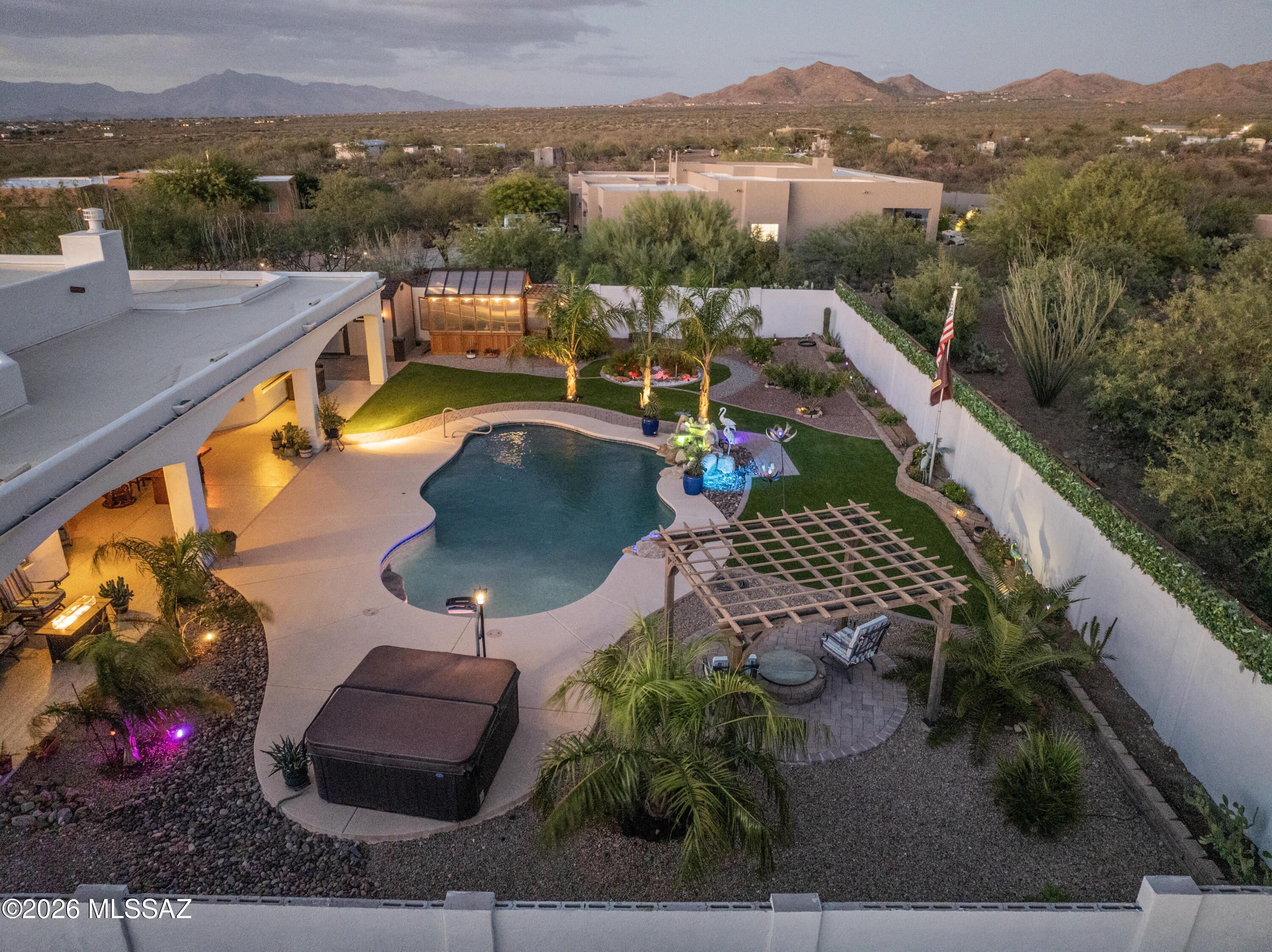 Luxury Living Meets Unforgettable Desert Beauty in Gated Sycamore Canyon. This is
the one buyers have been waiting for. Nestled on a private premium cul-de-sac lot spanning nearly an acre this exceptional semi-custom Sombra home captures breathtaking panoramic views of the Santa Rita Mountains and surrounding Tucson mountain ranges from nearly every room. Located within the highly acclaimed Vail School District, this residence offers the perfect blend of luxury, privacy, and Arizona lifestyle. Beautifully refreshed with new interior and exterior paint, this move-in-ready 4-bedroom, 3-bath home with a dedicated den/office showcases an expansive split-bedroom floor plan designed for both everyday comfort and effortless entertainment. The inviting courtyard entry welcomes you into a stunning great room featuring soaring ceilings, a charming beehive fireplace, surround sound pre-wire, and walls of windows that frame the spectacular mountain vistas. At the heart of the home, the gourmet chef's kitchen is designed to impress, featuring miles of granite countertops, custom cabinetry, stainless steel appliances, a gas cooktop, a walk-in pantry, and an oversized wraparound
breakfast bar perfect for gathering with family and friends. The spacious dining area and great room seamlessly flow to the outdoor living spaces through oversized sliding doors.
The luxurious primary retreat is a private sanctuary, offering stunning views, a spa-
inspired bath with soaking tub, walk-in shower, dual vanities, and a generous walk-in closet. The thoughtfully designed guest wing provides exceptional privacy with spacious secondary bedrooms and beautifully appointed bathrooms. Let's move outside and
experience your own desert resort. The extended full-width covered patio overlooks a sparkling PebbleTec pool with a waterfall, a relaxing spa, a lush turf area, and endless mountain views. You'll enjoy unmatched privacy, spectacular sunsets, and star-filled Arizona nights. A greenhouse and additional storage shed provide space for gardening, hobbies, and extra storage. Additional features include a 3-car garage with epoxy
flooring, zoned HVAC, ceiling fans throughout, water softener loop, a skylight in the laundry room, a long double driveway, and abundant storage. Rarely does a property combine this level of craftsmanship, privacy, breathtaking scenery, and resort-style amenities. This Sycamore Canyon retreat delivers the luxury lifestyle you've been searching for.