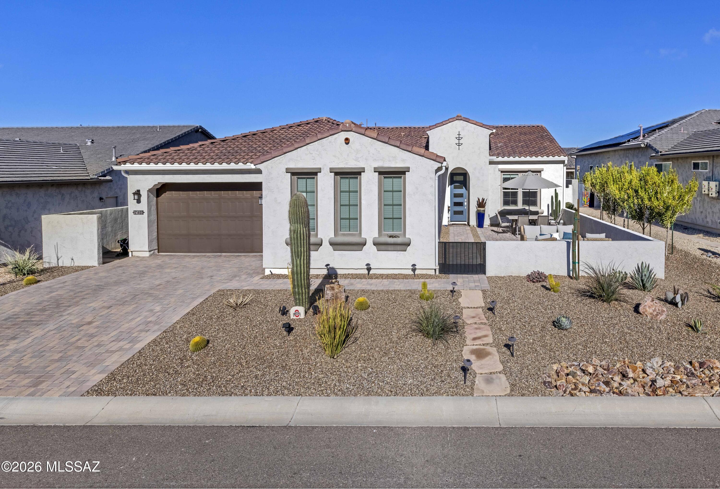 Introducing the Mira - a newer Robson-built model home located in the 55+ community of SaddleBrooke Ranch. Enjoy stunning views of the Catalina Mountains and Mount Lemmon from the expansive paved front courtyard, the perfect spot to relax with a glass of wine and take in Arizona sunsets. The open-concept great room and dining area feature expansive sliding doors that flood the home with natural light and open to the rear lawn area. The highly upgraded kitchen offers 42'' gray upper cabinets, matching gray cabinetry throughout, white quartz countertops, a large island with breakfast bar, high ceilings, stainless steel appliances with chimney hood, a bar fridge, and a walk-in pantry. The den with barn doors captures more mountain views. The primary suite includes an ensuite bath.