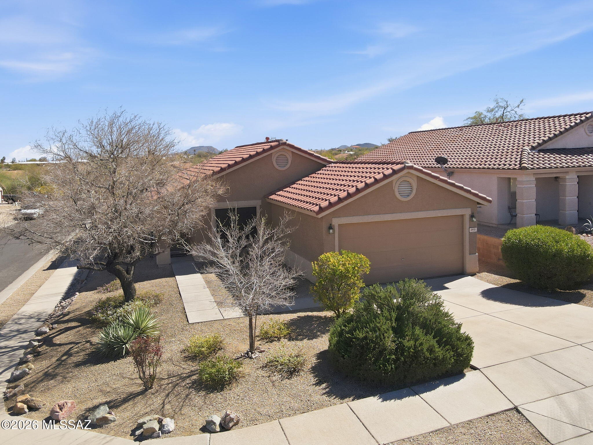 Located in the desirable gated community of Sweetwater Reserve, this Tucson AZ 85745 single story premium corner lot home offers 3 bedrooms, 2 baths, and 1,560 sq ft with natural slate tile flooring, new tile flooring in bedrooms and baths, fresh interior paint, new window blinds and new kitchen appliances. Washer and dryer included. Mature desert landscaping with irrigation, pergola covered  patio, pavers, and low-maintenance backyard. New Epoxy garage floor with built-in storage. Community pool with Tucson Mountain views and close proximity to hiking at Sweetwater Preserve. Experience serene Sonoran Desert living on Tucson's desirable west side. This move-in ready home blends comfort and functionality with an open-concept layout and abundant natural light. The kitchen features brand-new appliances and ample cabinetry, flowing seamlessly into dining and living spaces ideal for entertaining.

The beautifully landscaped front yard showcases flowering trees and established plantings, while the private backyard retreat offers a covered ramada patio, concrete pavers, and decorative rock--perfect for relaxing or hosting gatherings under Arizona sunsets.

The upgraded garage includes a newly finished epoxy floor, workbench, ceiling-mounted storage racks, and wall organization system for exceptional utility.

Residents of Sweetwater Reserve enjoy gated privacy and a community pool positioned to capture panoramic west mountain range views. Conveniently located near I-10, Downtown Tucson dining, shopping, and outdoor recreation, this property offers the perfect balance of mountain views, desert tranquility, and city accessibility.